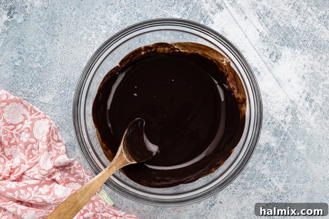 melted chocolate in a bowl with a wooden spoon, ready for the next steps of brownie preparation