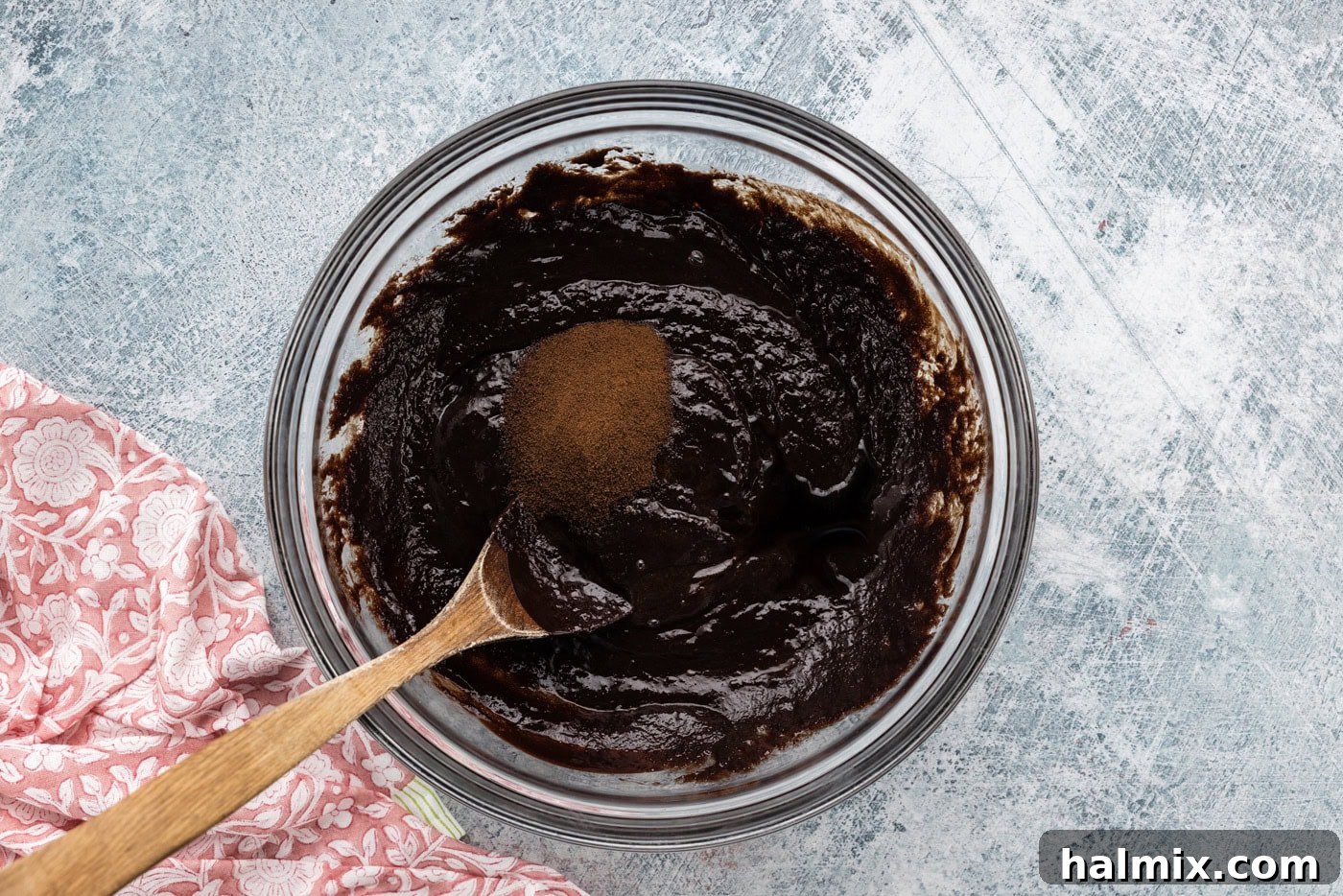 espresso powder being added to a bowl of rich brownie batter, enhancing the chocolate flavor