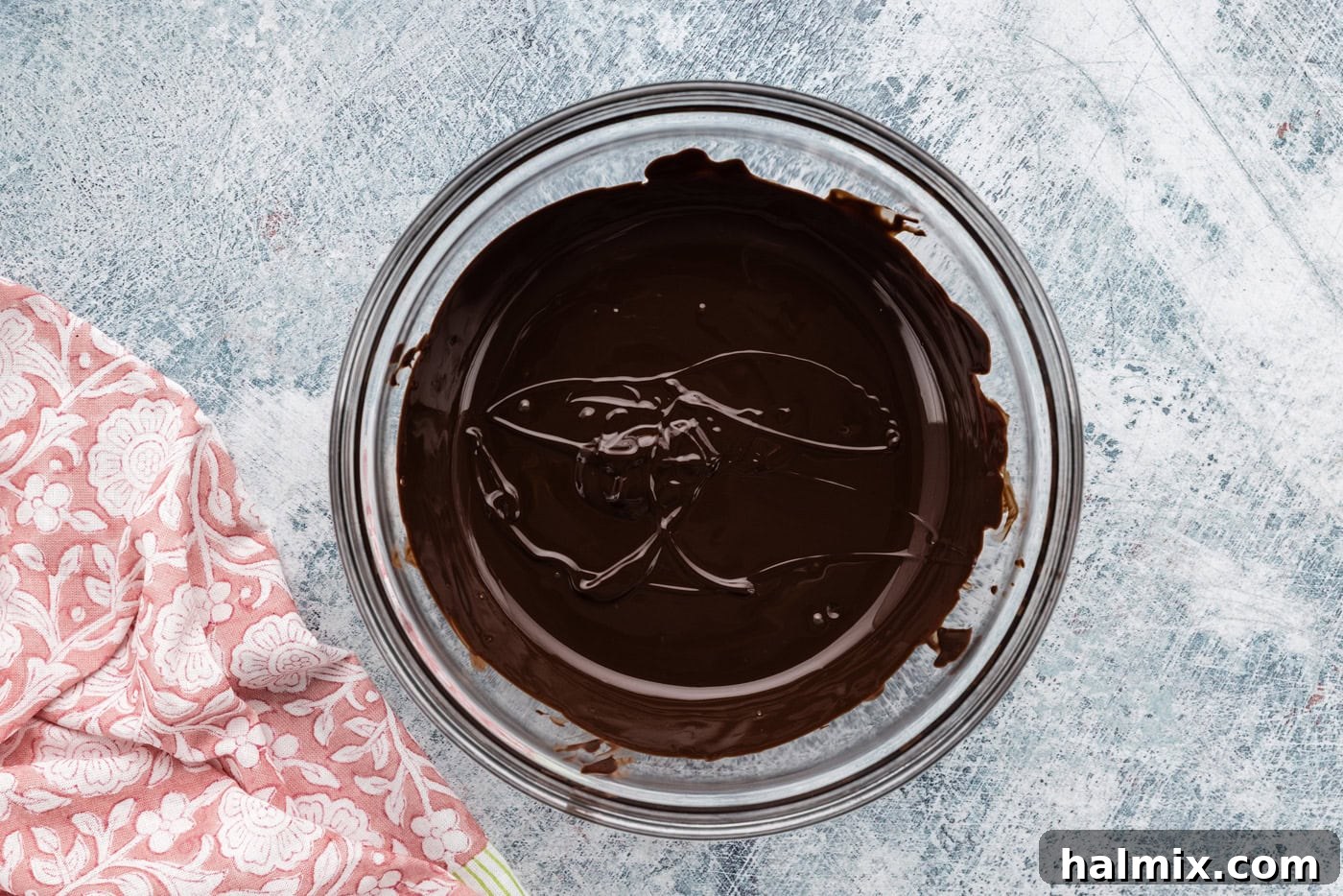 smooth, melted chocolate in a bowl, ready to be incorporated into the fudge frosting