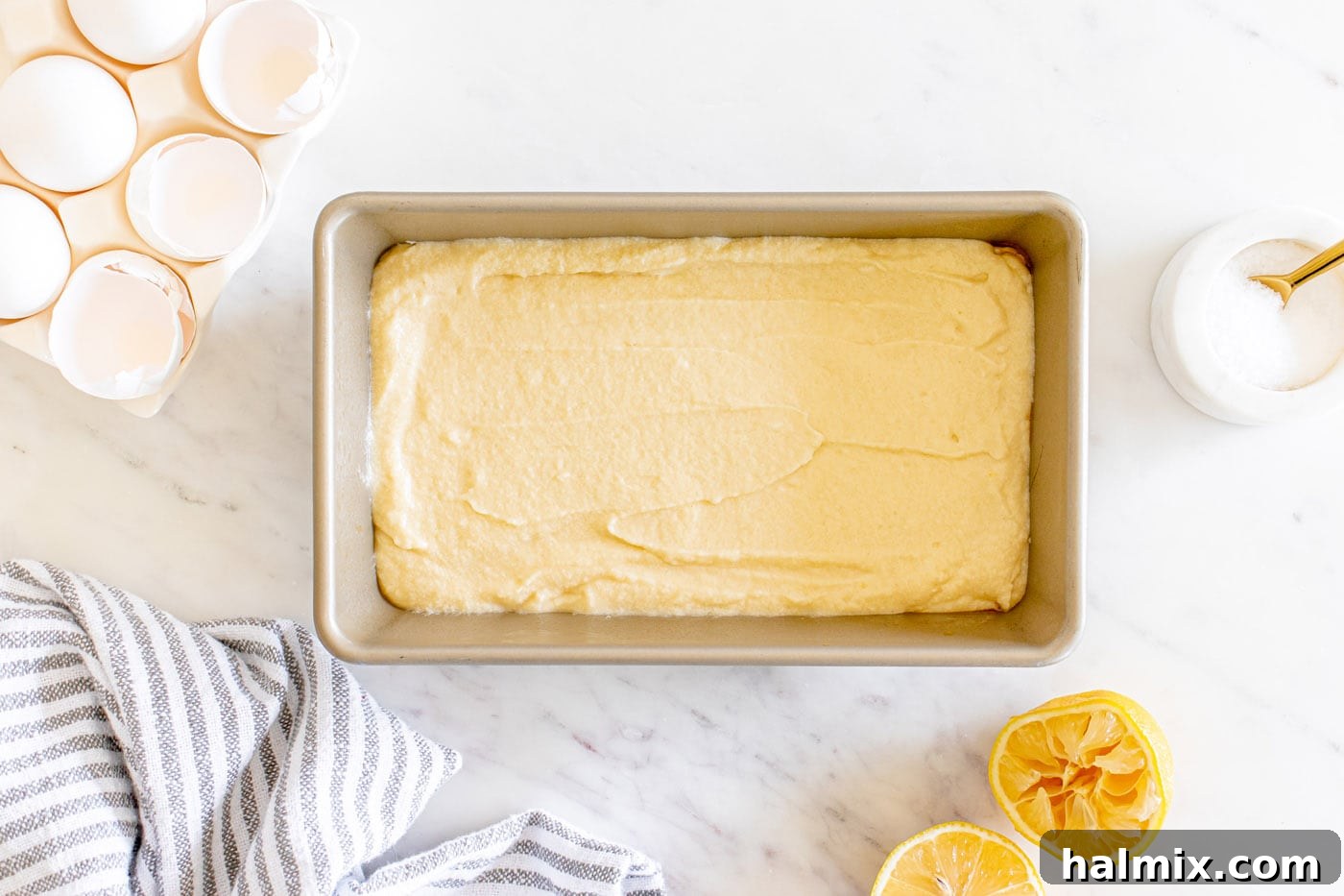 Lemon pound cake batter spread evenly in a loaf pan, ready for the oven.