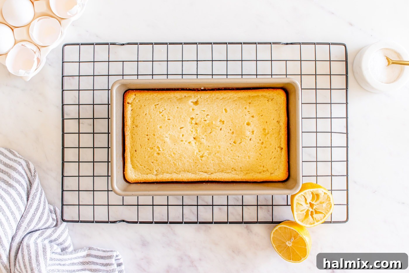 A golden-brown baked lemon loaf cooling on a wire rack.