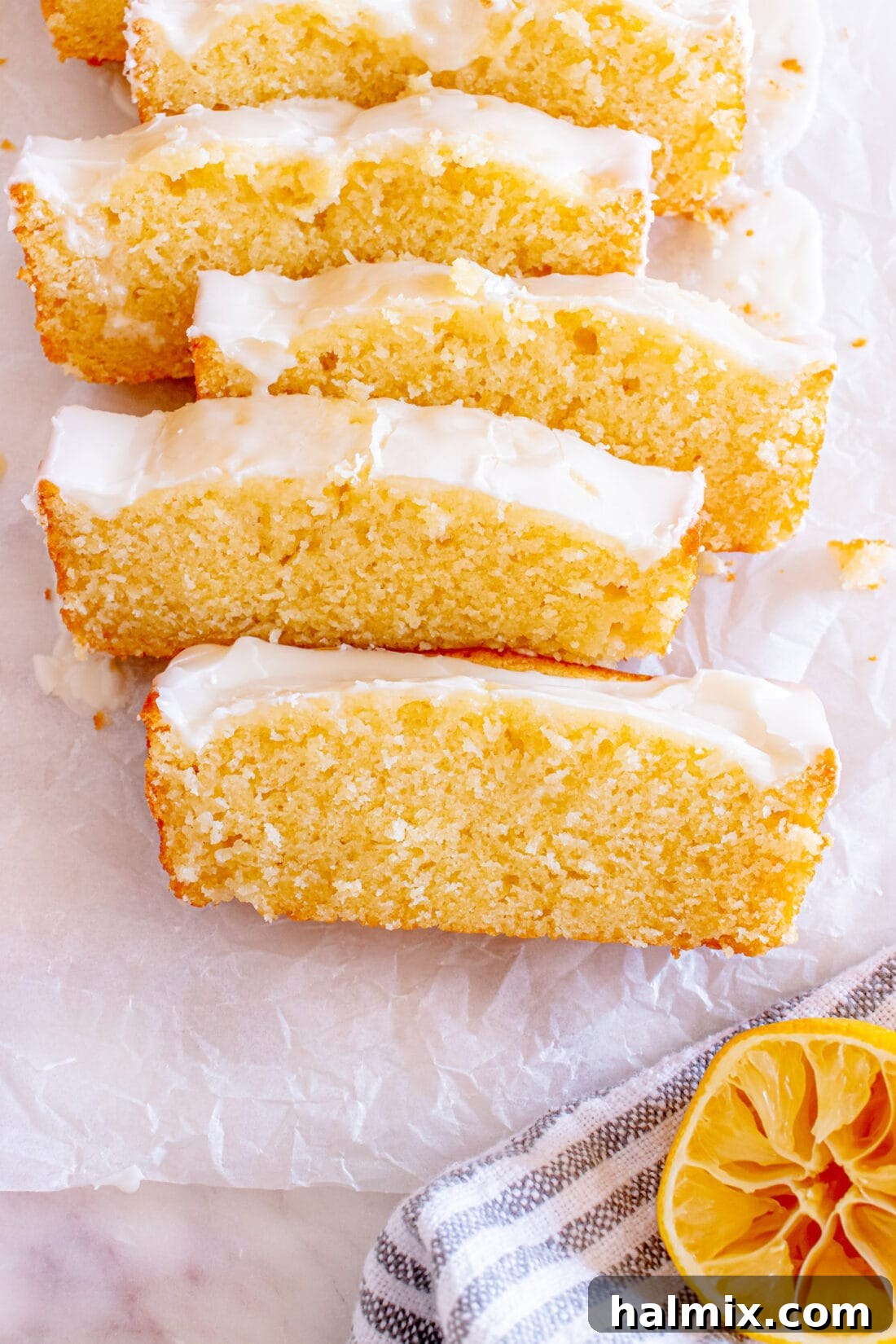 Close up photo of perfectly sliced Lemon Pound Cake revealing its moist interior and thick, luscious glaze.