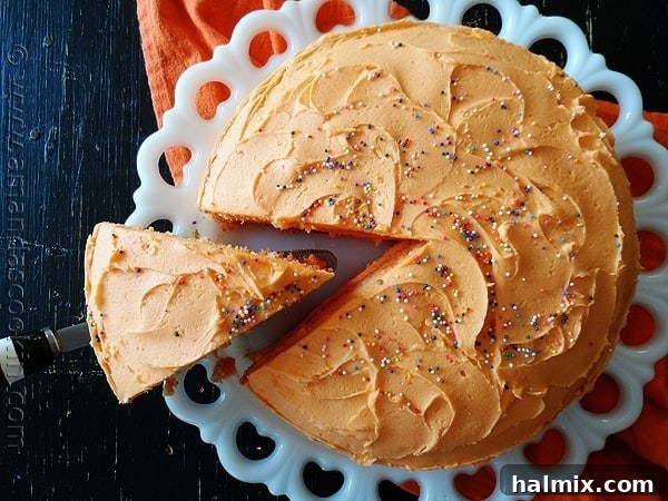 A close-up of the delicate texture of the Orange Poke Cake, showing the infusion of gelatin within the cake layers.