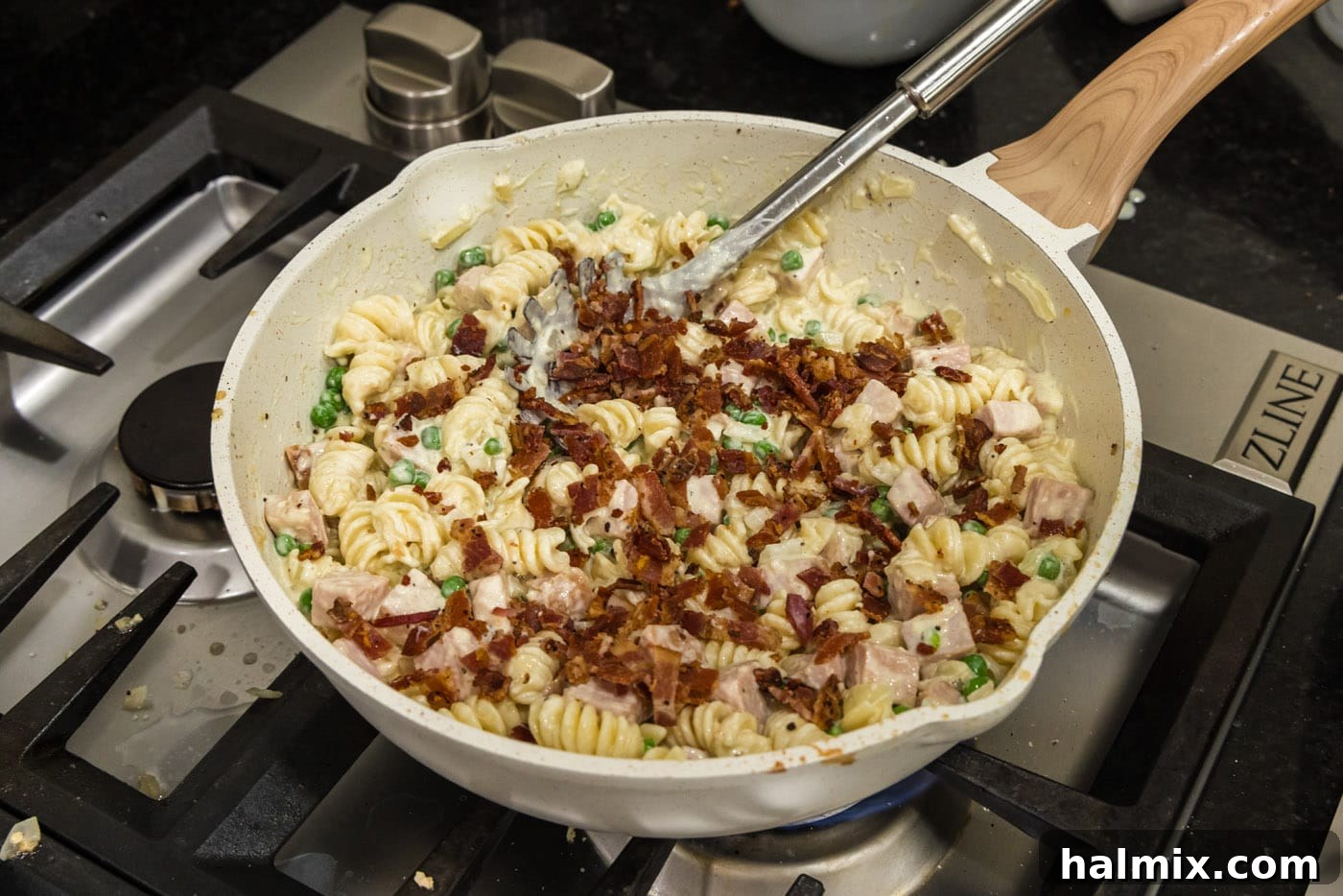 Crispy diced cooked bacon sprinkled into the skillet with the Turkey Carbonara, completing the dish with savory notes.