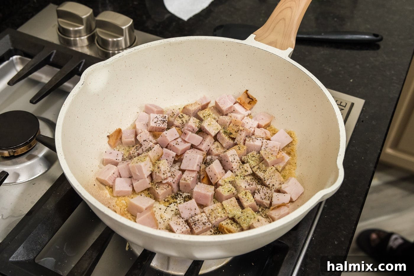 Cubed turkey and seasonings added to the olive oil and garlic mixture in a skillet, beginning to brown and absorb the flavors.