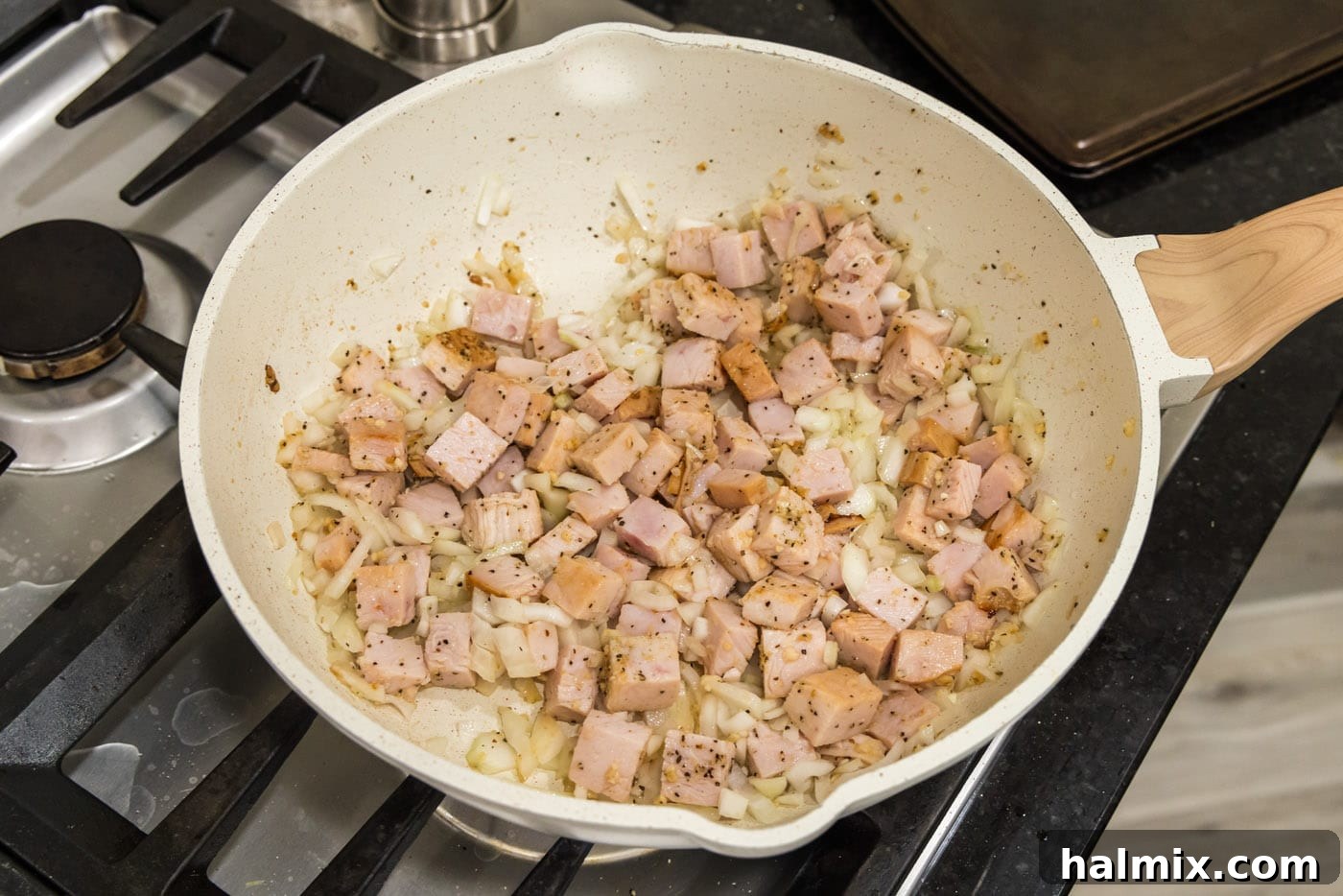 Sautéed cubed turkey combined with softened onion and fragrant garlic in a skillet.