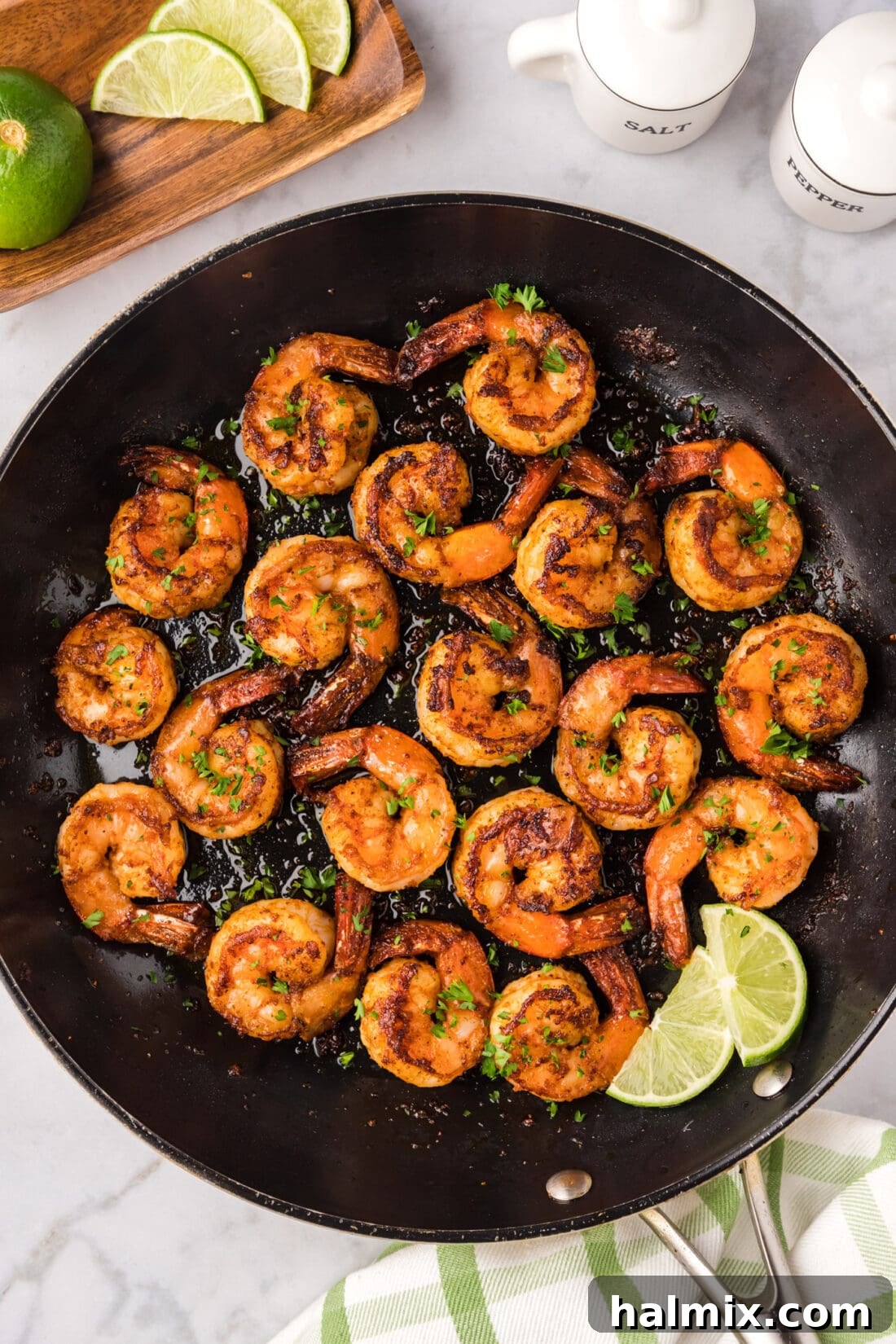 Close up photo of a skillet of Spicy Shrimp, showcasing the vibrant colors and appealing texture of the cooked shrimp.