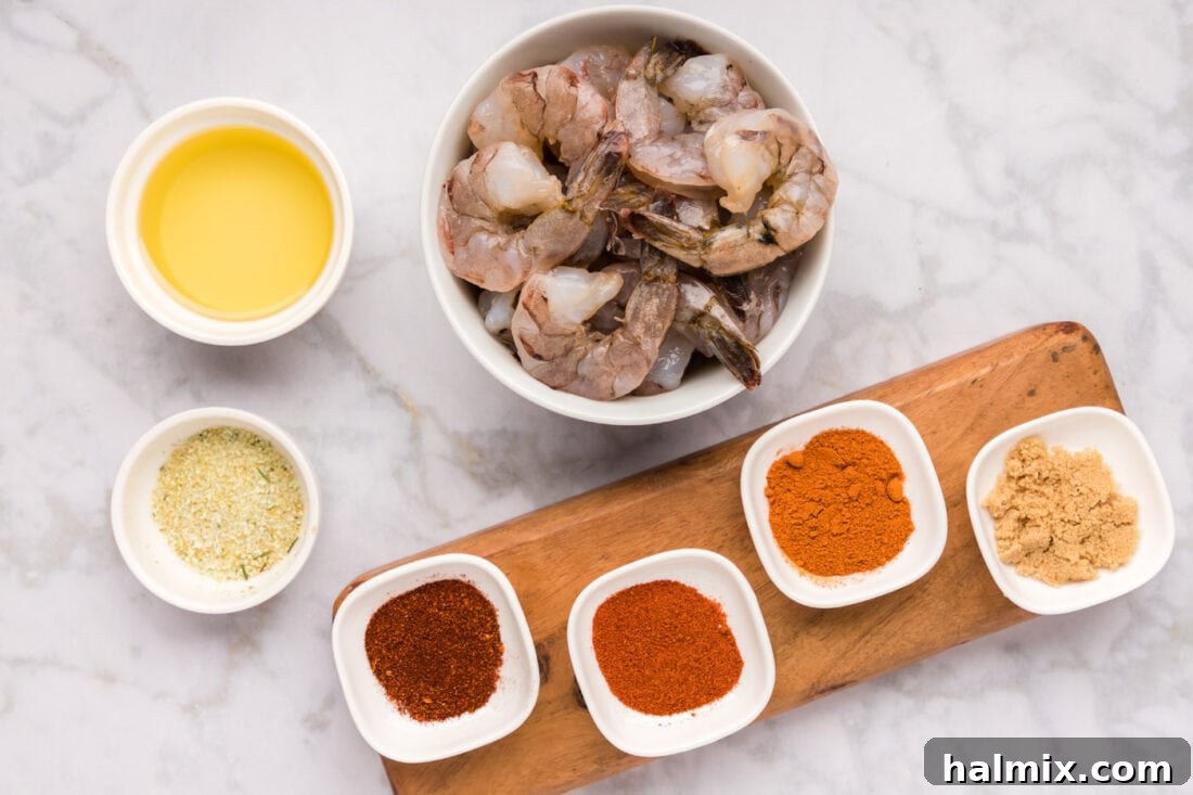 A flat lay photograph displaying all the fresh ingredients and spices needed for the Spicy Shrimp recipe.