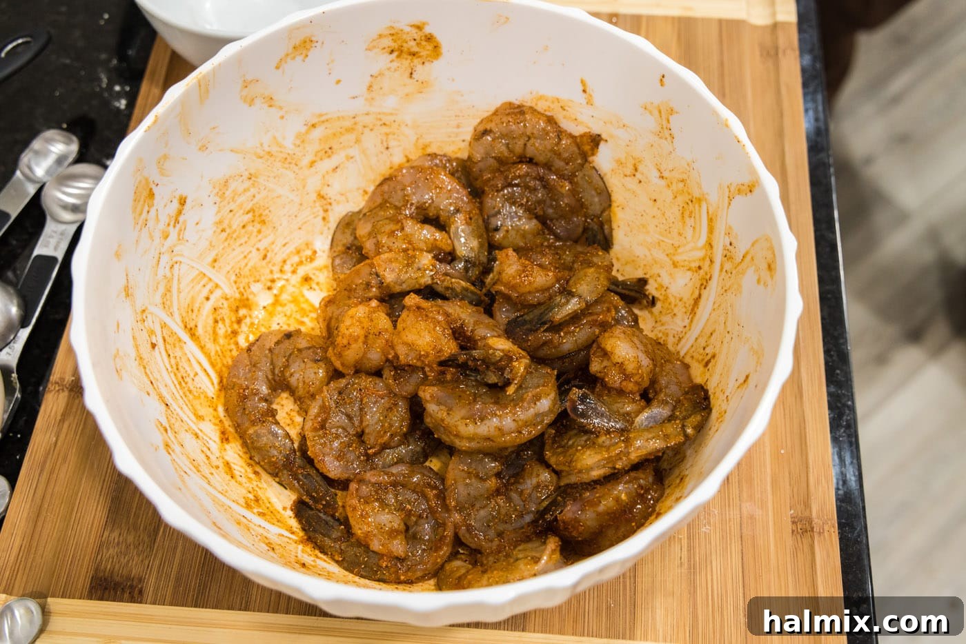 Shrimp tossed in cayenne pepper, chili powder, and paprika, showing the even coating.