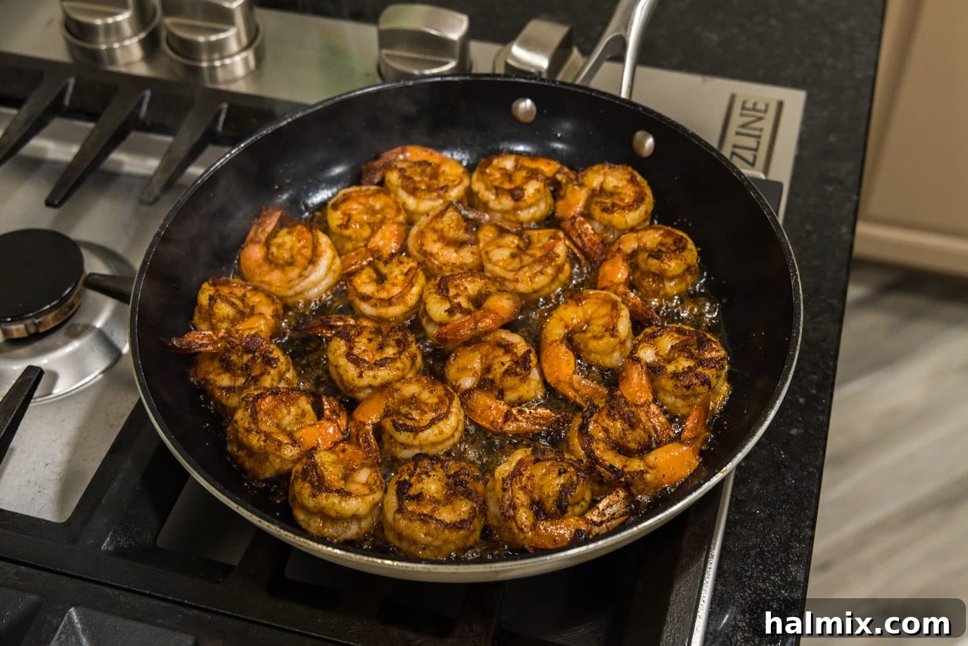 Cooked seasoned shrimp in a skillet, showcasing their vibrant color and seared edges.