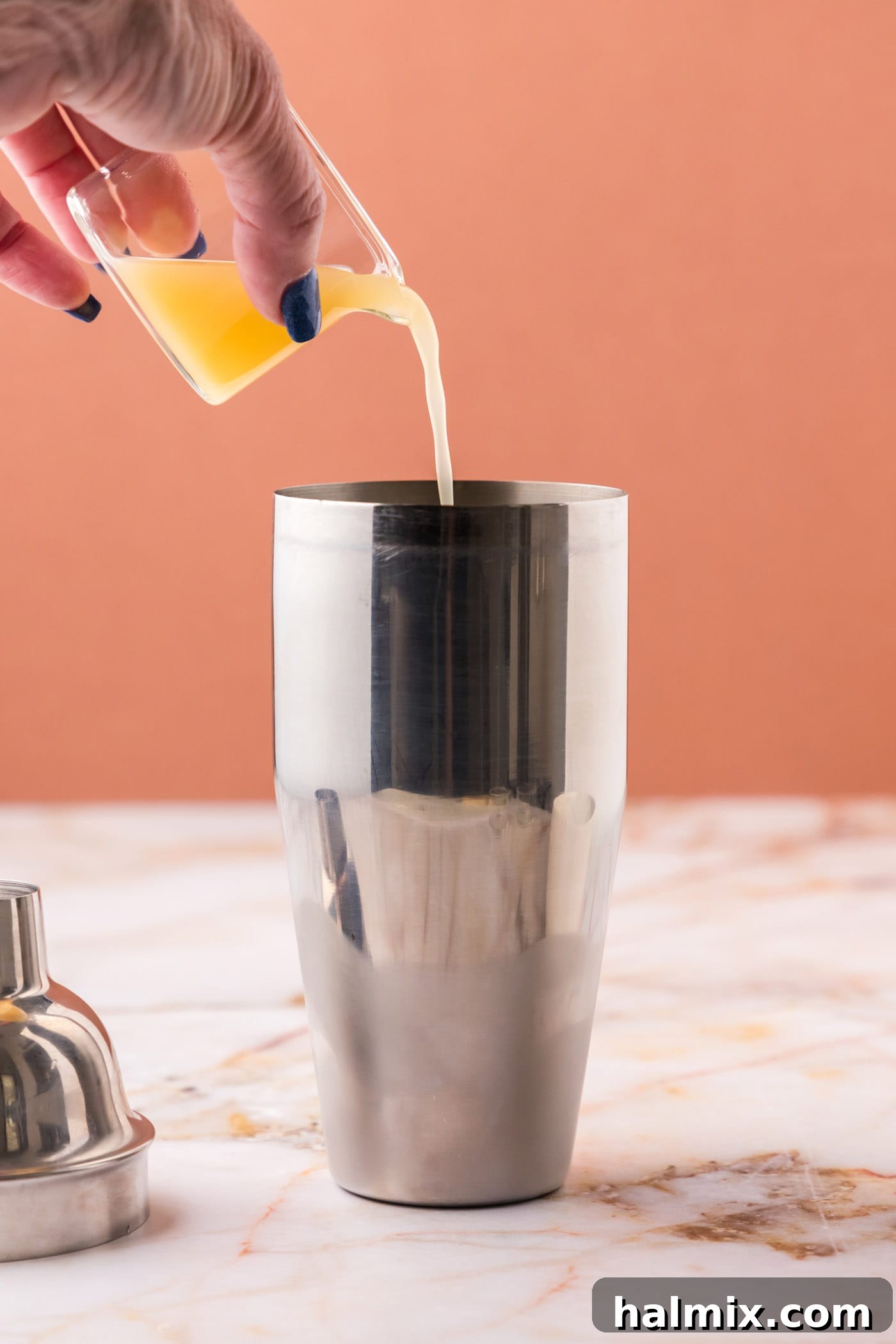 pouring pineapple juice into cocktail shaker