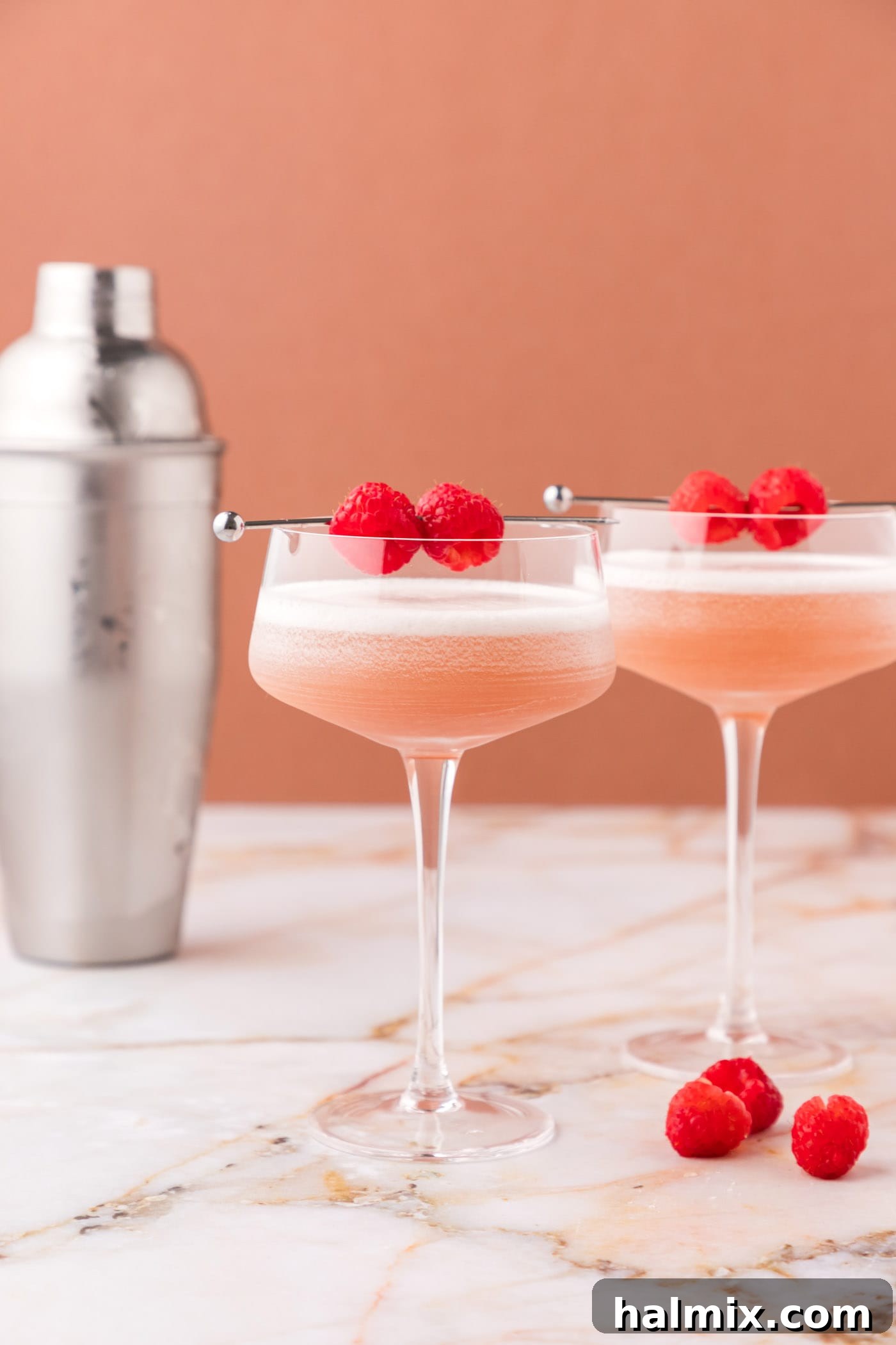 two french martinis with a garnish of fresh raspberries