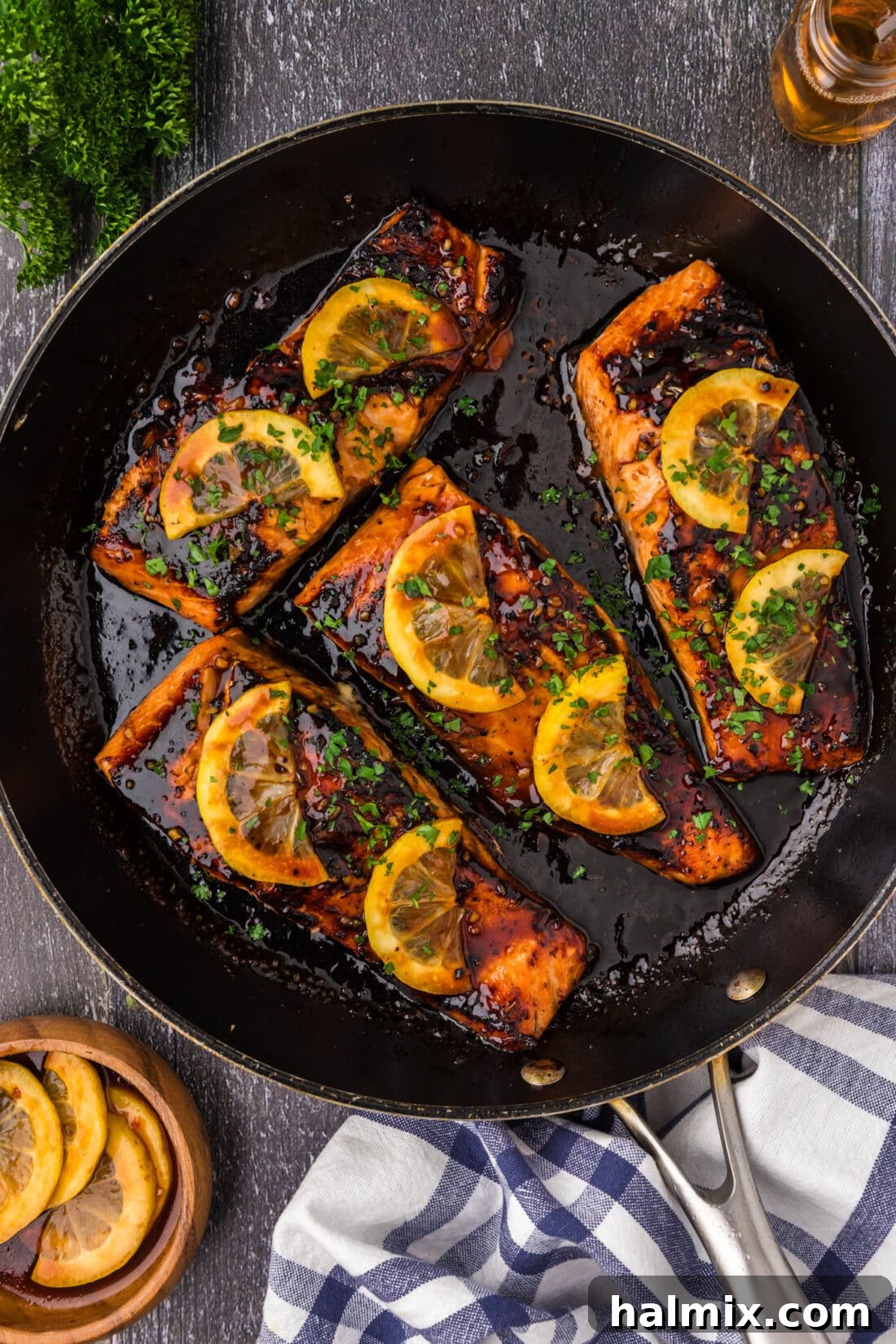 Honey Salmon in a skillet topped with lemon slices, ready to serve.