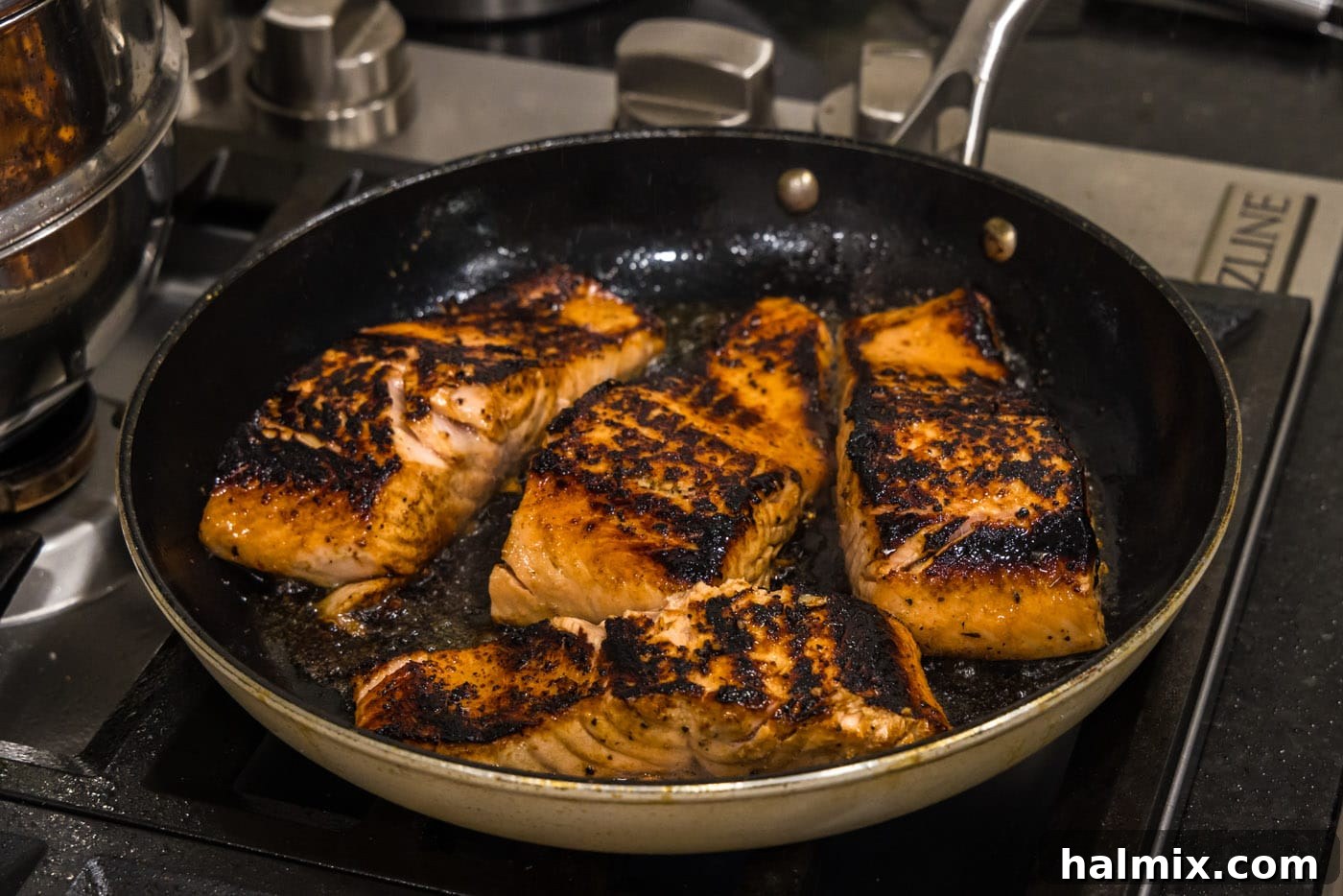 Perfectly seared salmon fillets in a skillet.