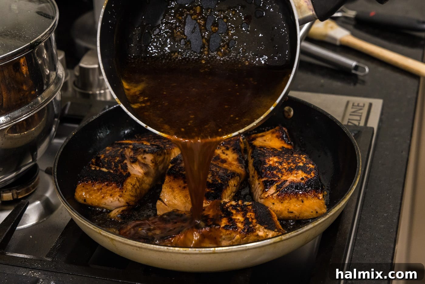 Pouring the luscious honey glaze over salmon fillets as they finish cooking in the skillet.