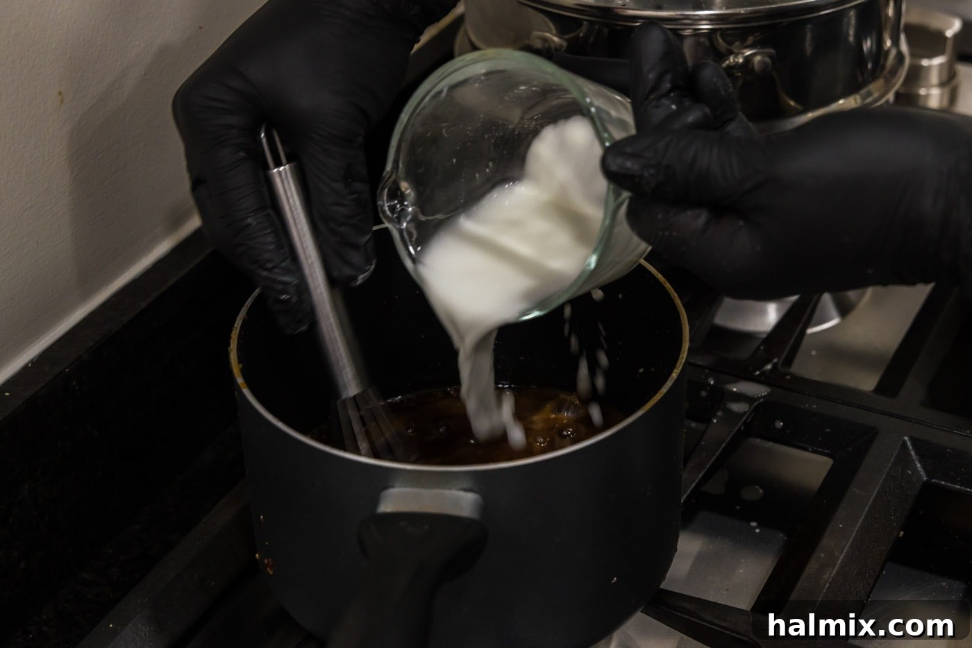 Pouring cornstarch slurry into the simmering honey glaze for salmon.