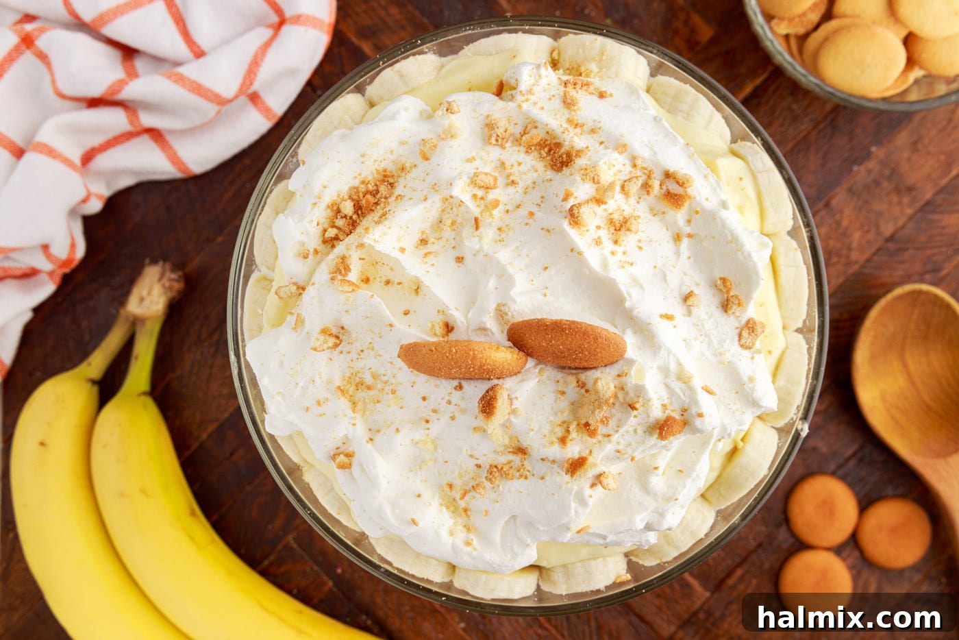 Garnished banana trifle with whipped cream, whole, and crushed Nilla wafers on top.
