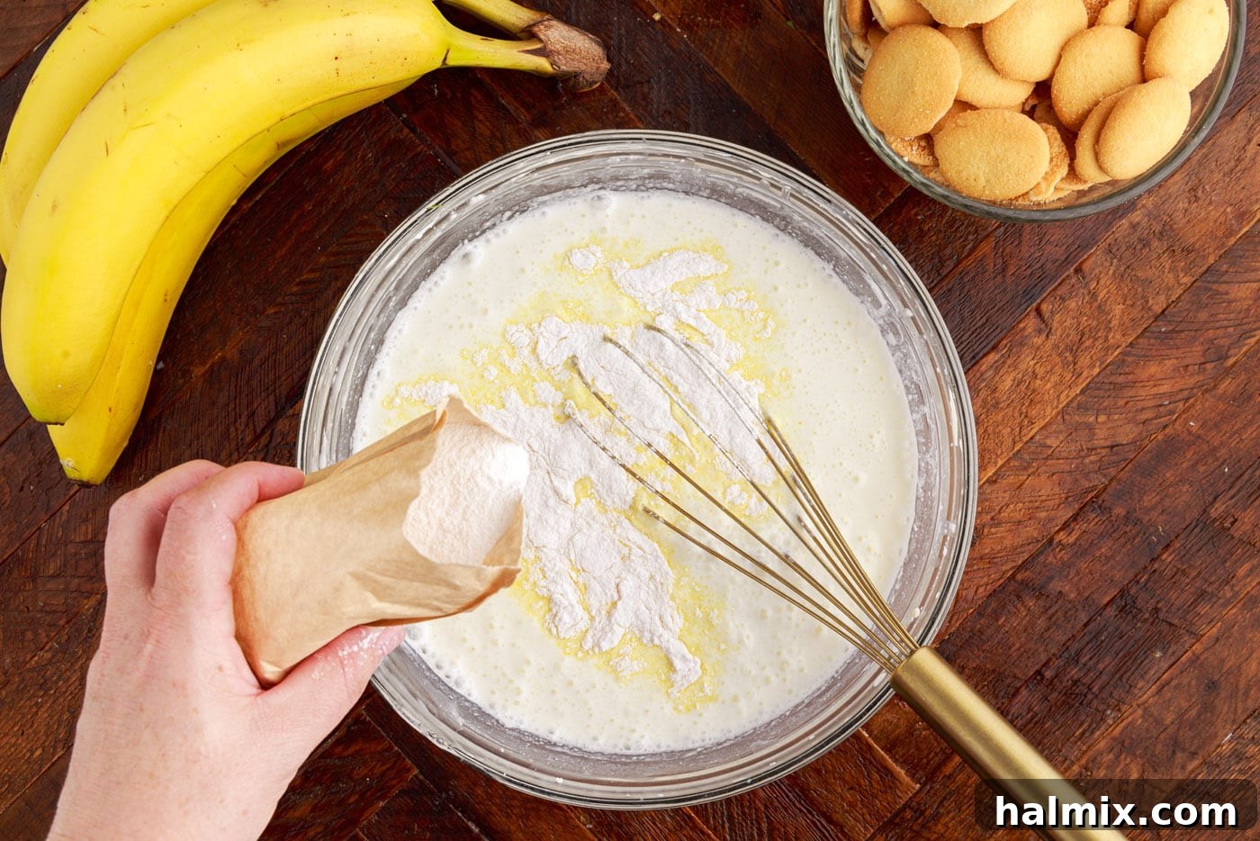 Whisking instant vanilla pudding mix into the cream cheese and milk mixture.