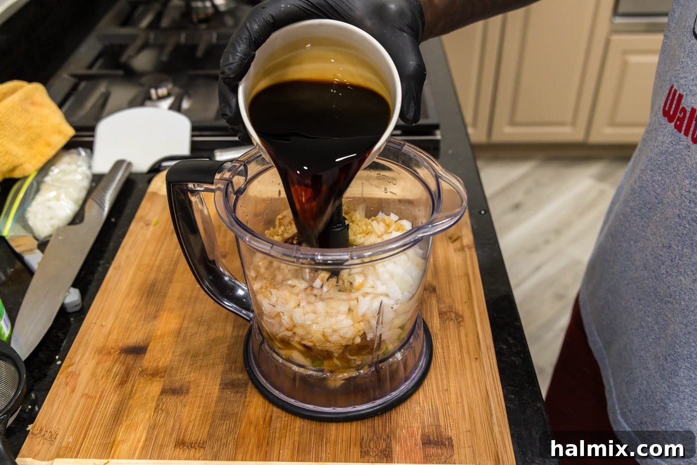 pouring soy sauce into food processor with Korean marinade ingredients