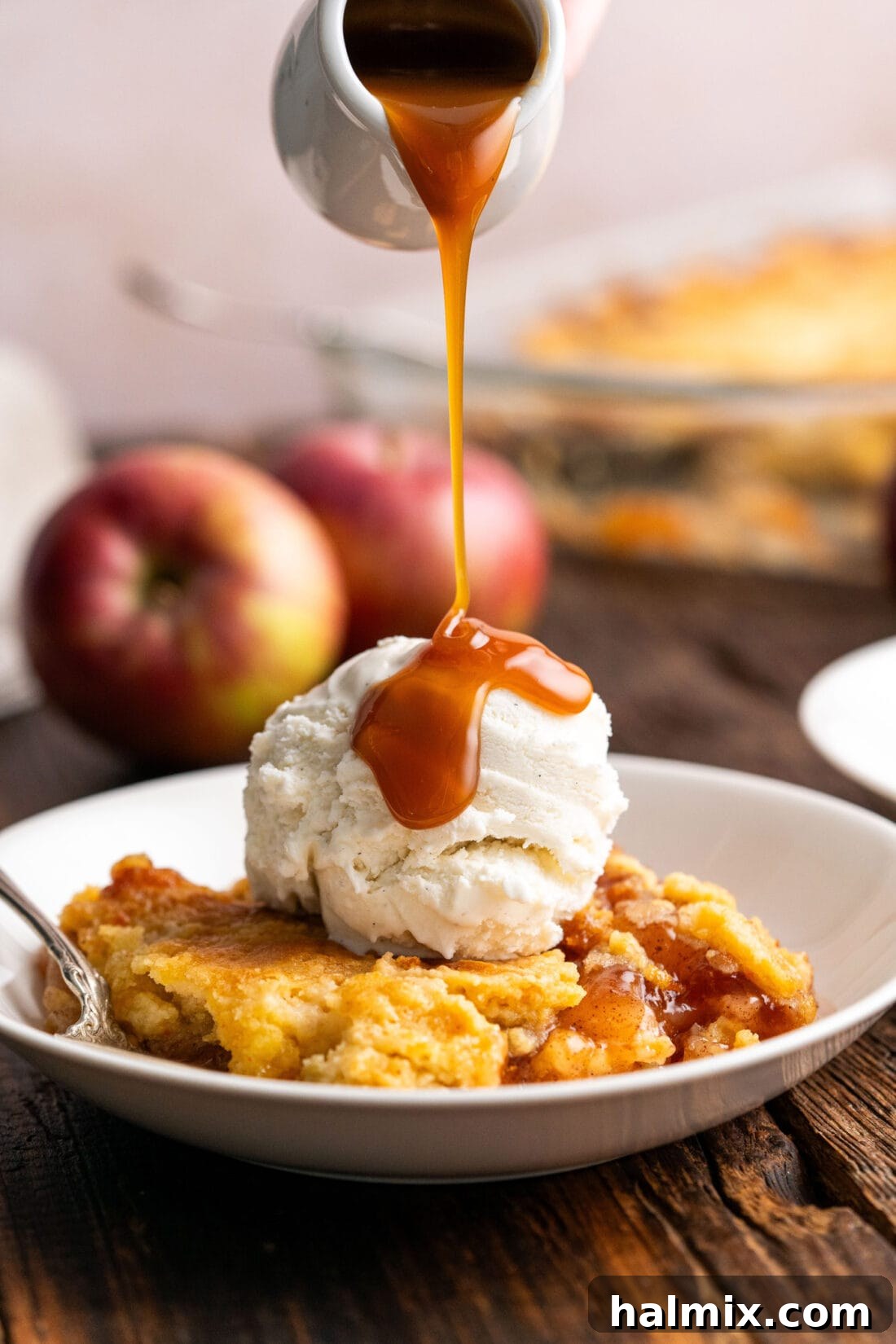 No-Fuss Caramel Apple Delight 2 Caramel sauce being drizzled over Caramel Apple Dump Cake topped with ice cream