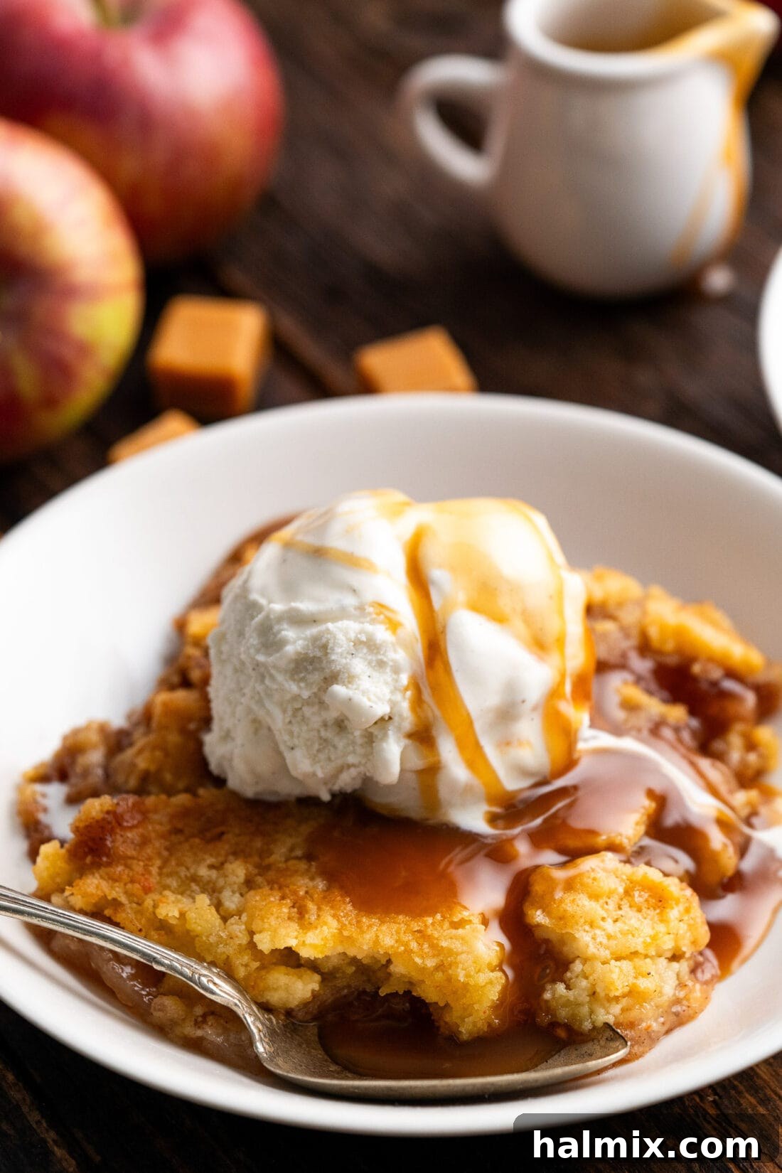 No-Fuss Caramel Apple Delight 13 Caramel Apple Dump Cake in a bowl topped with ice cream and caramel sauce