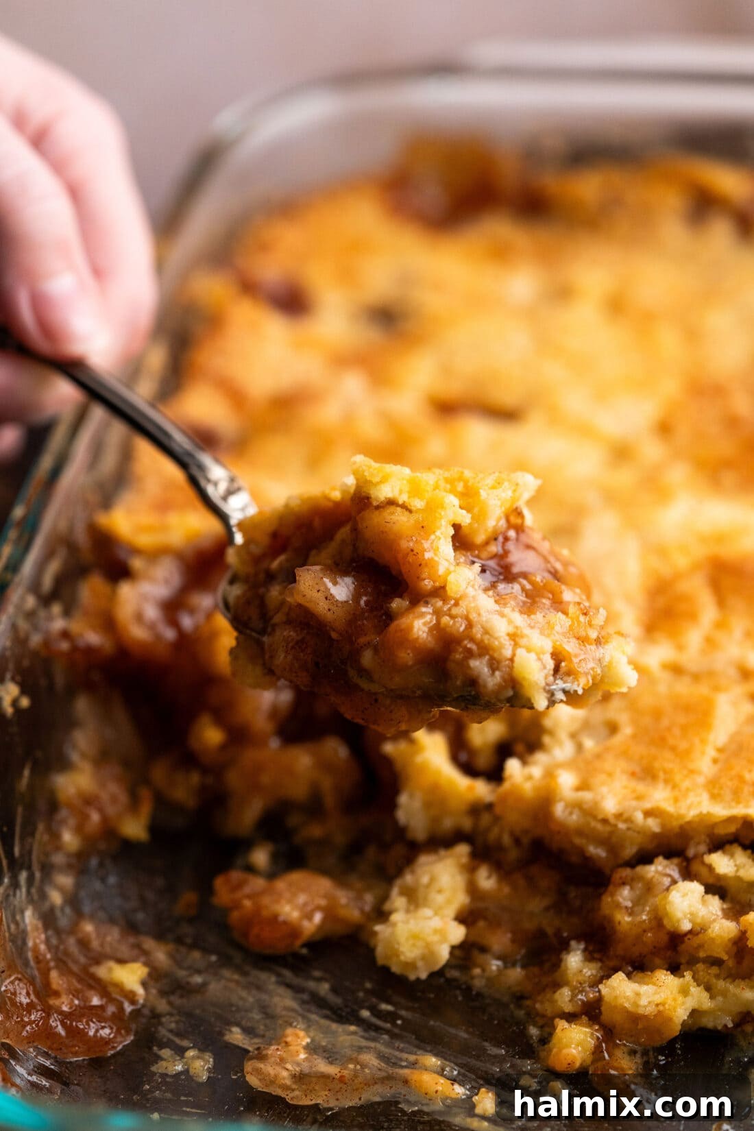 No-Fuss Caramel Apple Delight 3 Scoop of Caramel Apple Dump Cake being lifted out of the pan