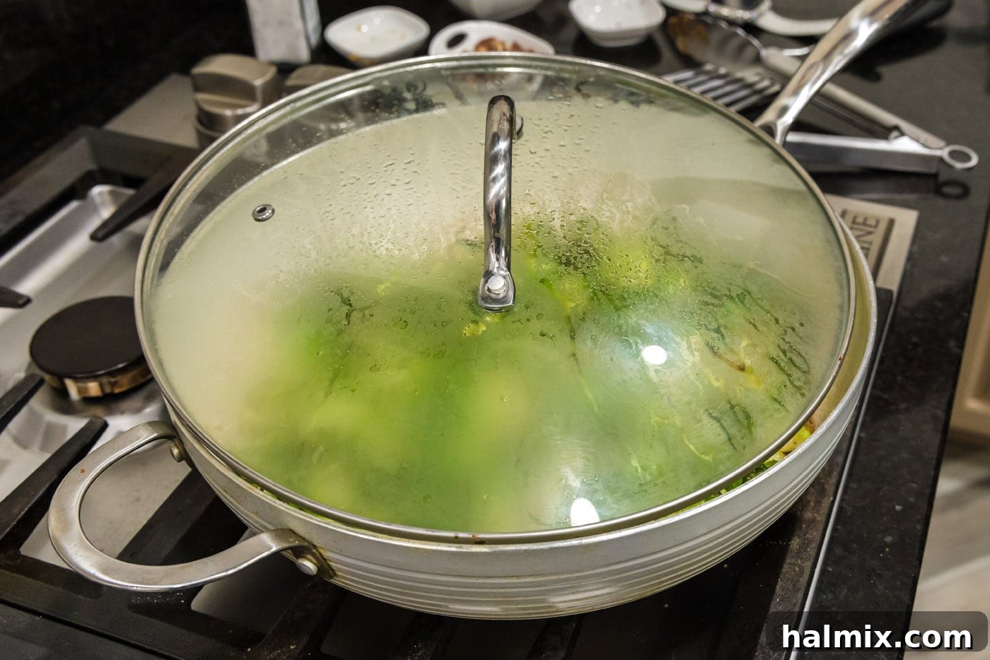 lid over the top of brussels sprouts in a skillet, tilted to allow steam escape