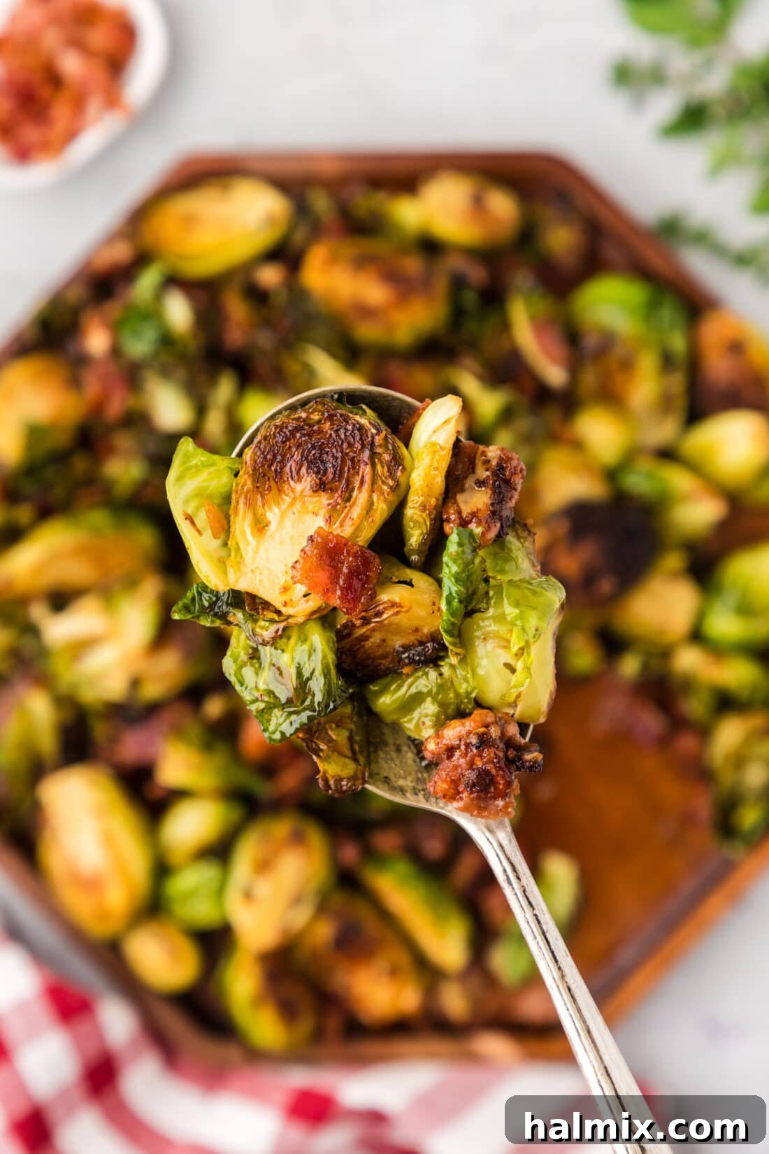 Close up photo of a spoonful of Brussels Sprouts with Bacon, Shallots and Candied Pecans, ready to be served