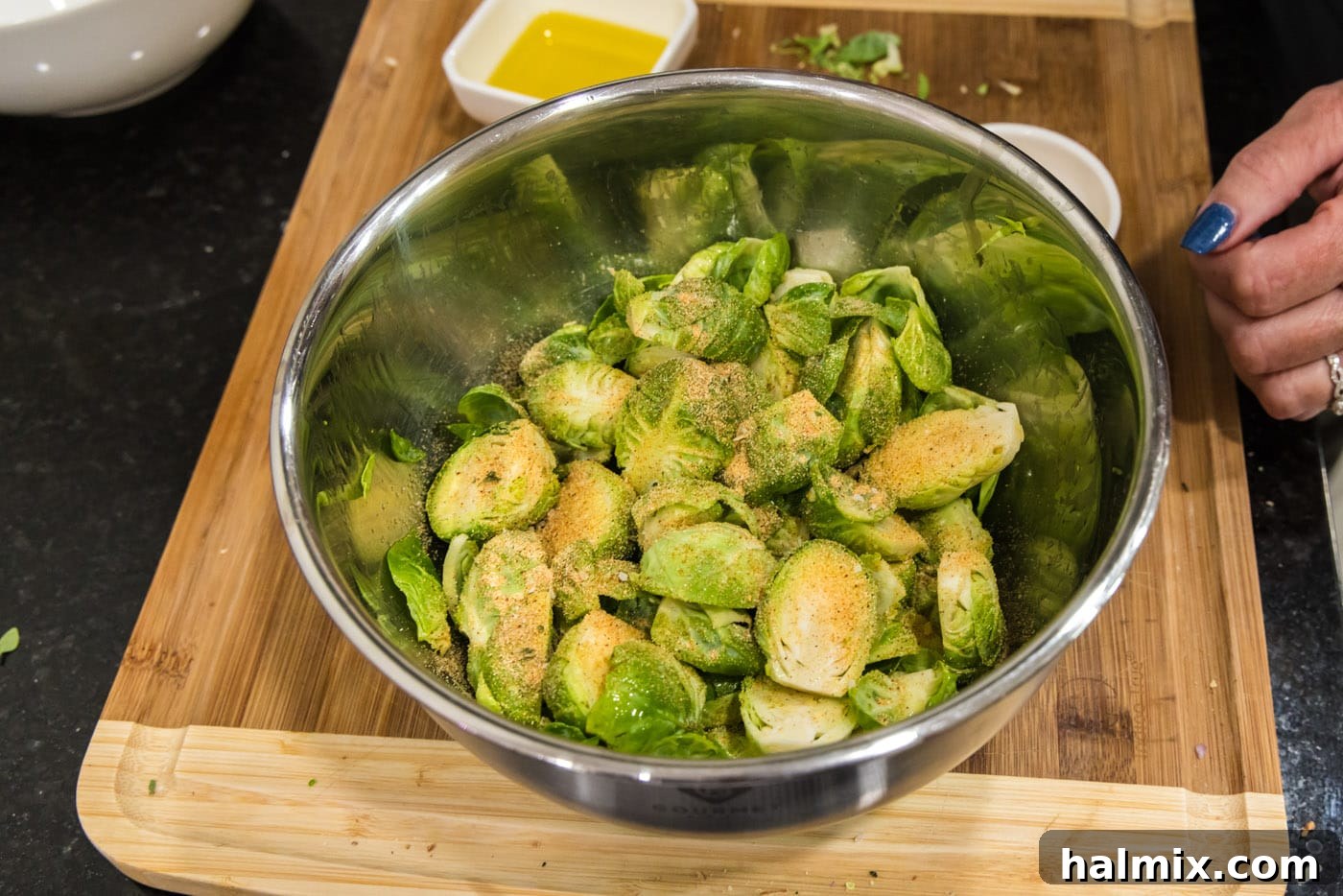 brussels sprouts in a bowl with seasoning, showing the even coating