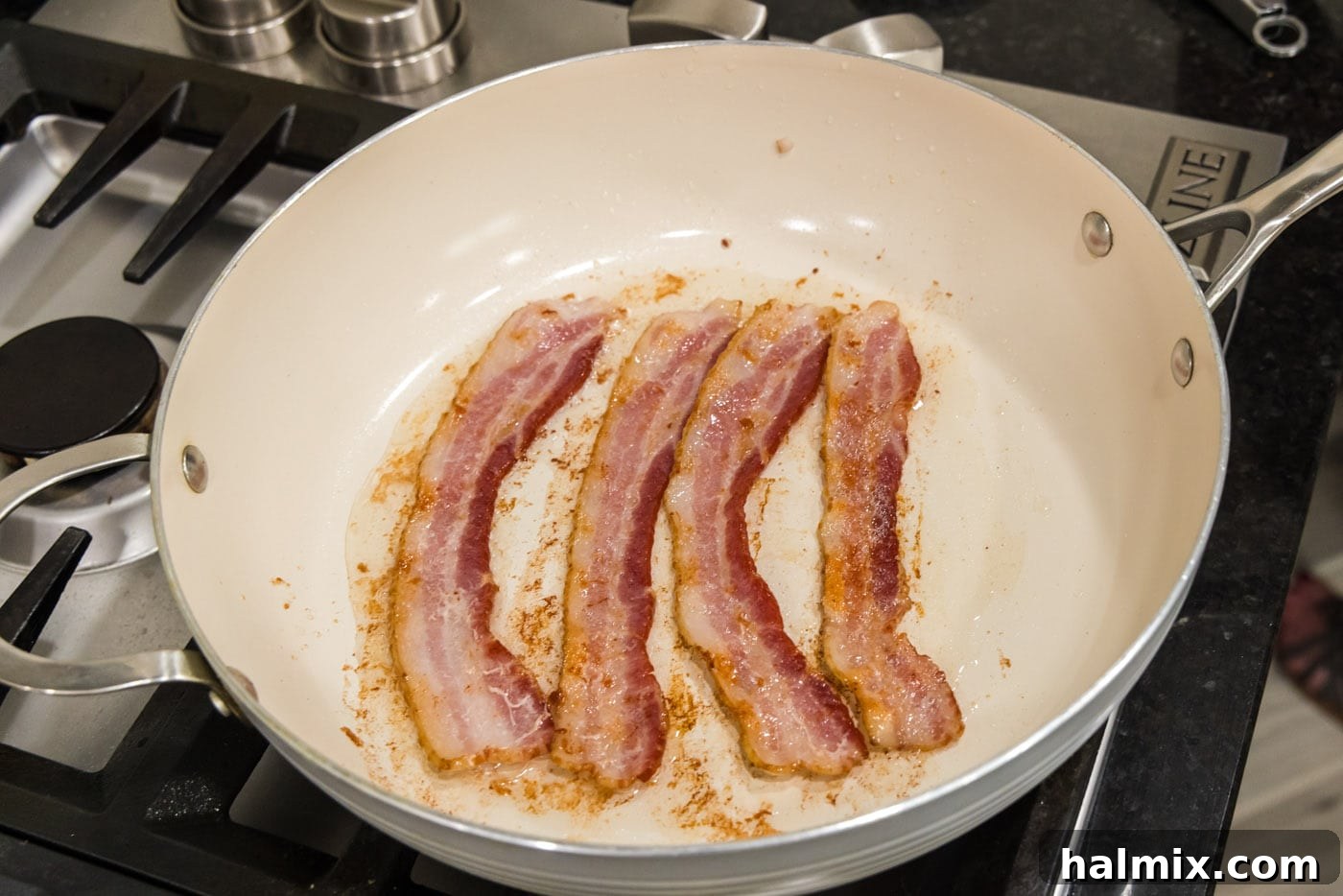 cooked bacon strips in a skillet, showing perfectly rendered bacon before removal
