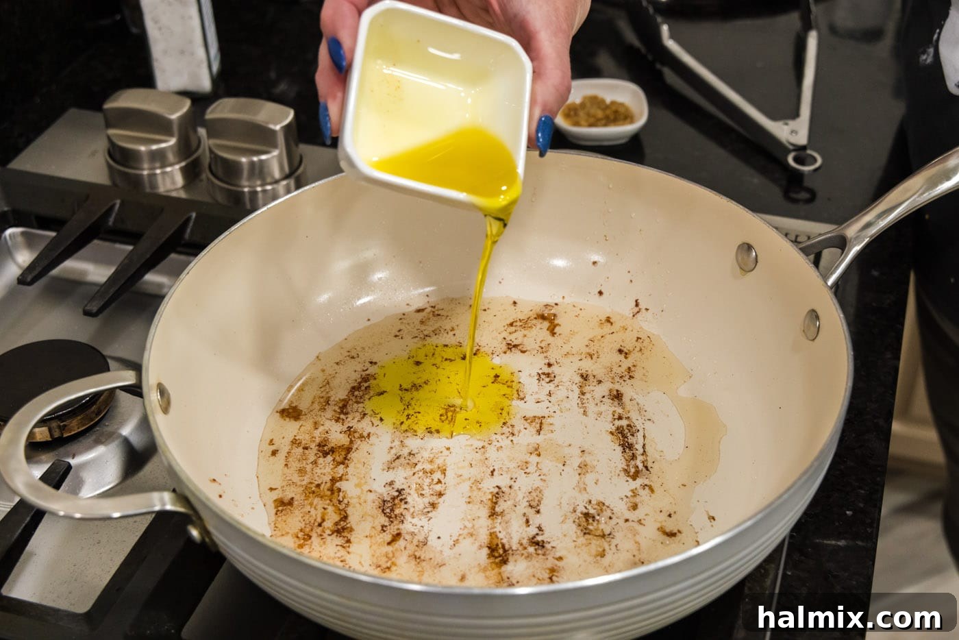 pouring oil into a skillet with rendered bacon fat