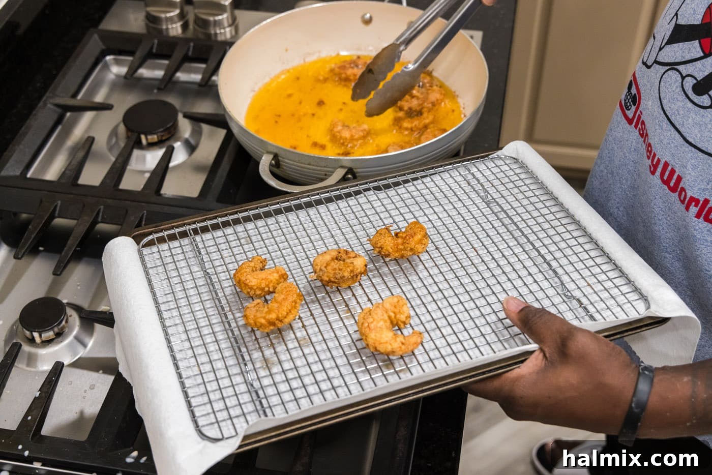 Electric Shrimp Bites 11 tongs removing fried shrimp from oil