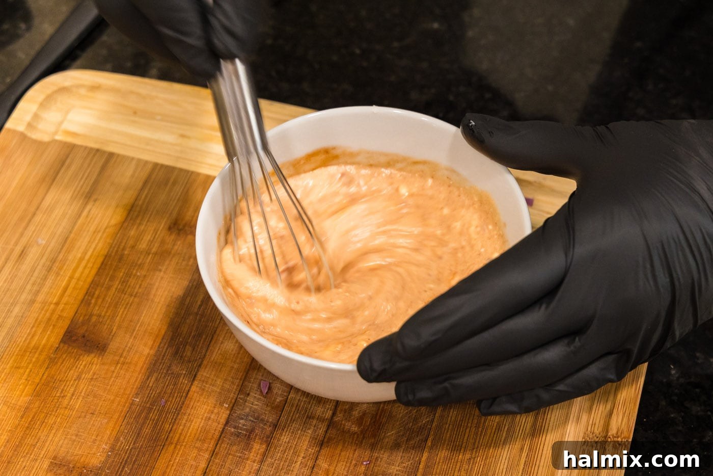 Electric Shrimp Bites 5 whisking bang bang sauce in a bowl