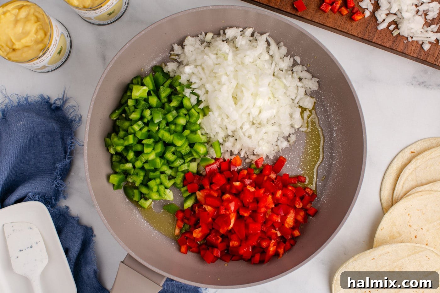 Hearty King Ranch Chicken Bake 5 Diced bell peppers and onion sautéing in a skillet with olive oil.