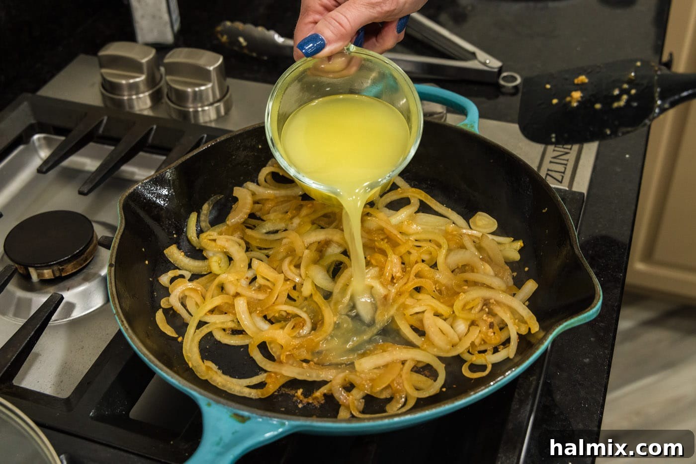 Pouring chicken broth into skillet with sautéed onions