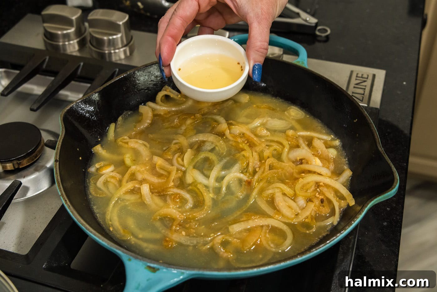 Adding rice vinegar to the onion and chicken broth mixture