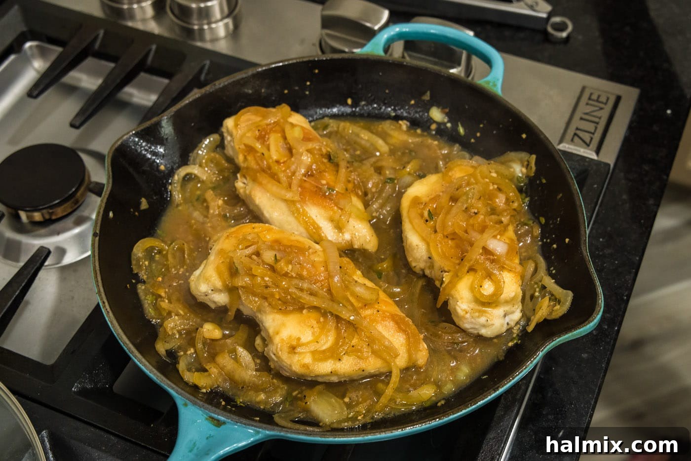 Chicken breasts perfectly coated in onion thyme sauce in a skillet