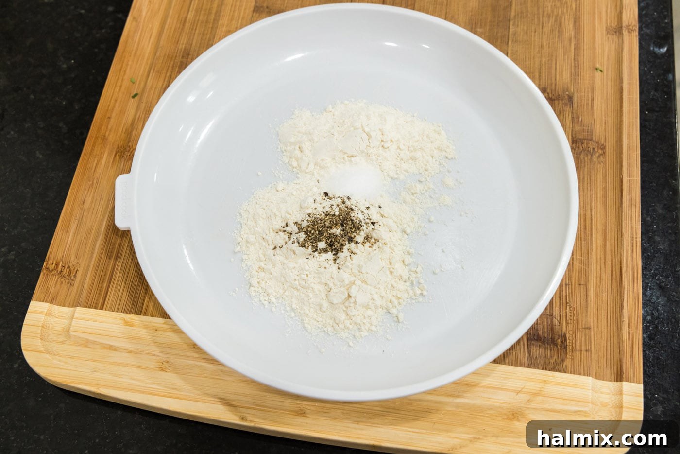 Flour with salt and pepper on a plate for dredging chicken