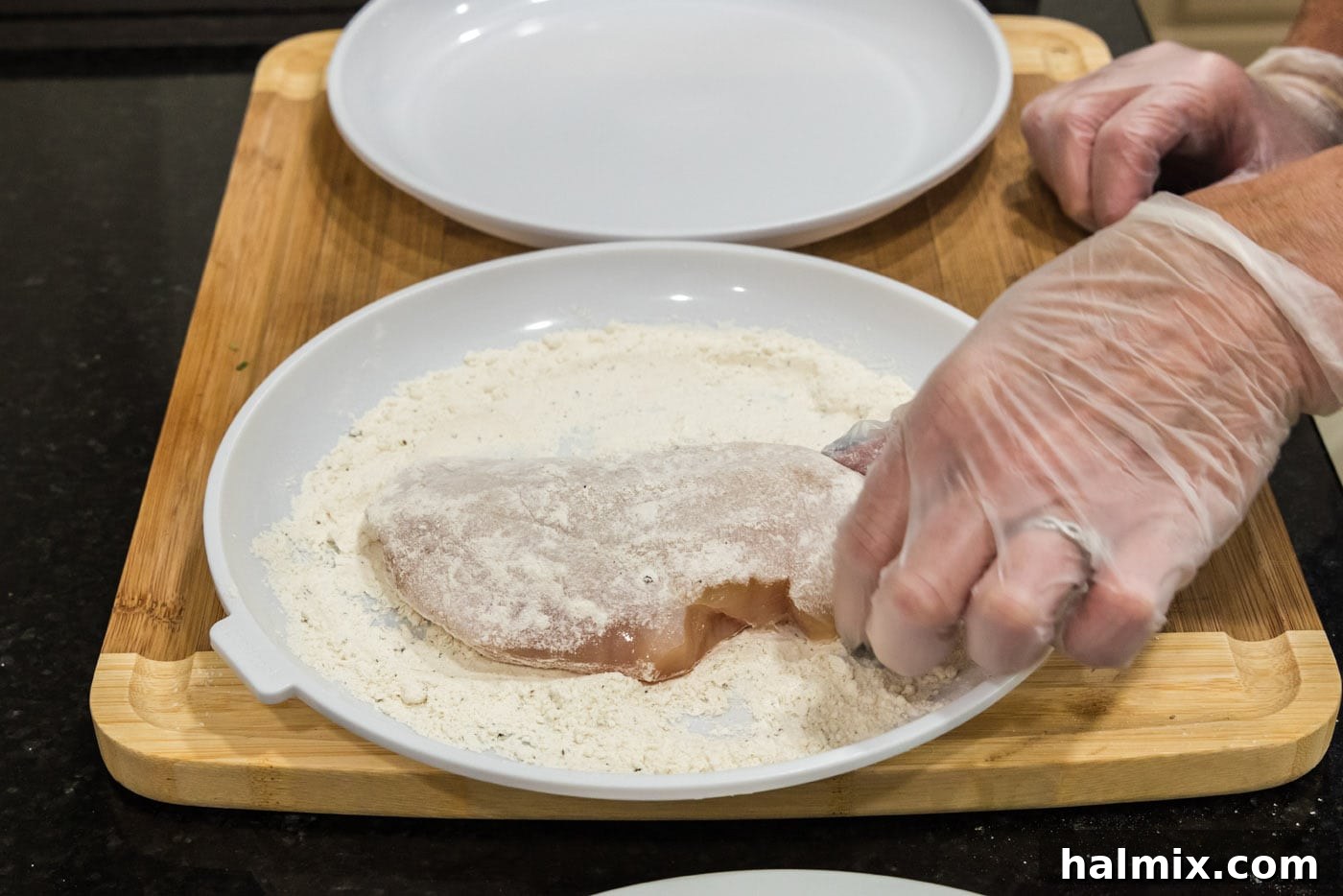 Dredging chicken breast in flour mixture