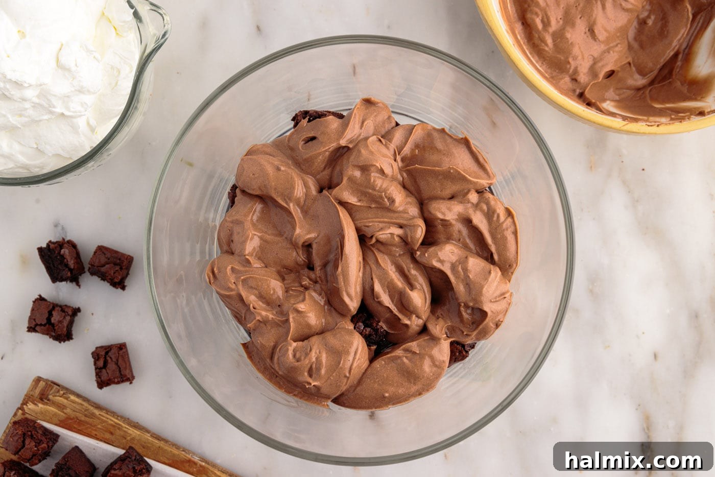 Ultimate Fudge Brownie Trifle 11 Half of the whipped chocolate pudding mixture being spread over the first layer of brownies