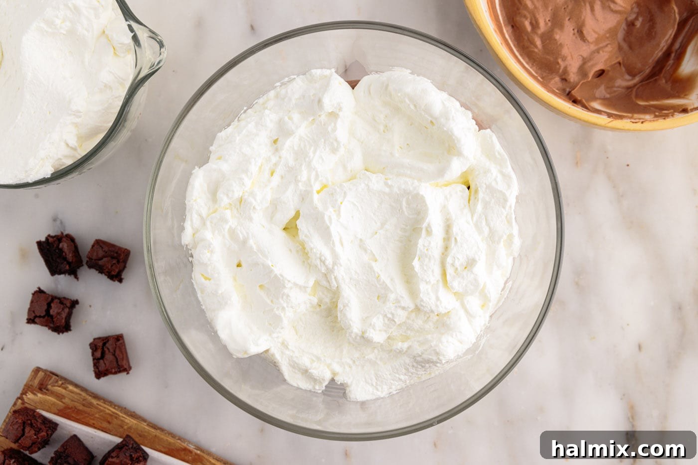 Ultimate Fudge Brownie Trifle 12 Half of the remaining whipped cream being layered on top of the chocolate pudding and brownies
