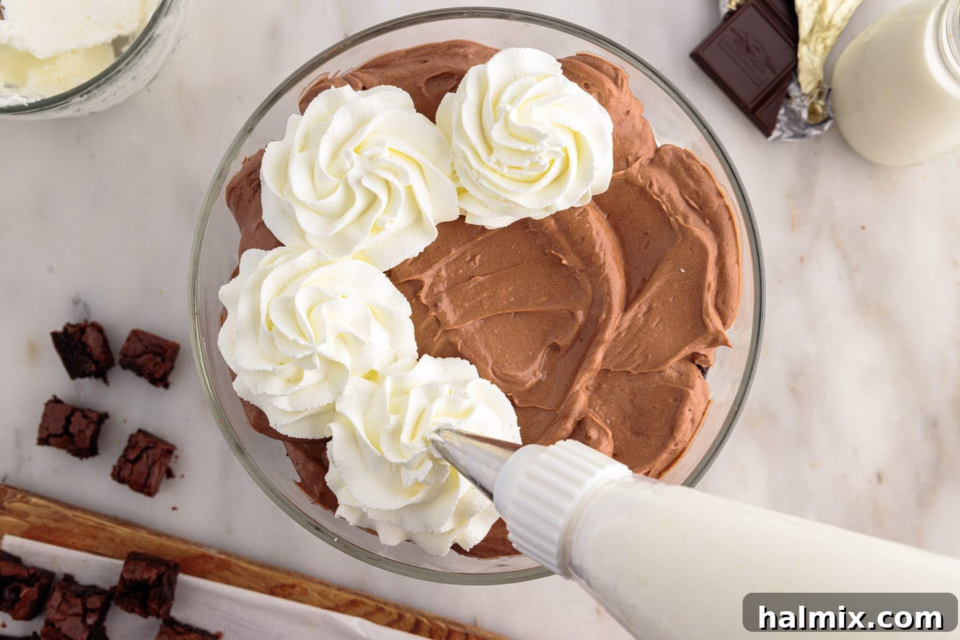 Ultimate Fudge Brownie Trifle 13 Piping the remaining whipped cream in decorative swirls on top of the completed brownie trifle layers