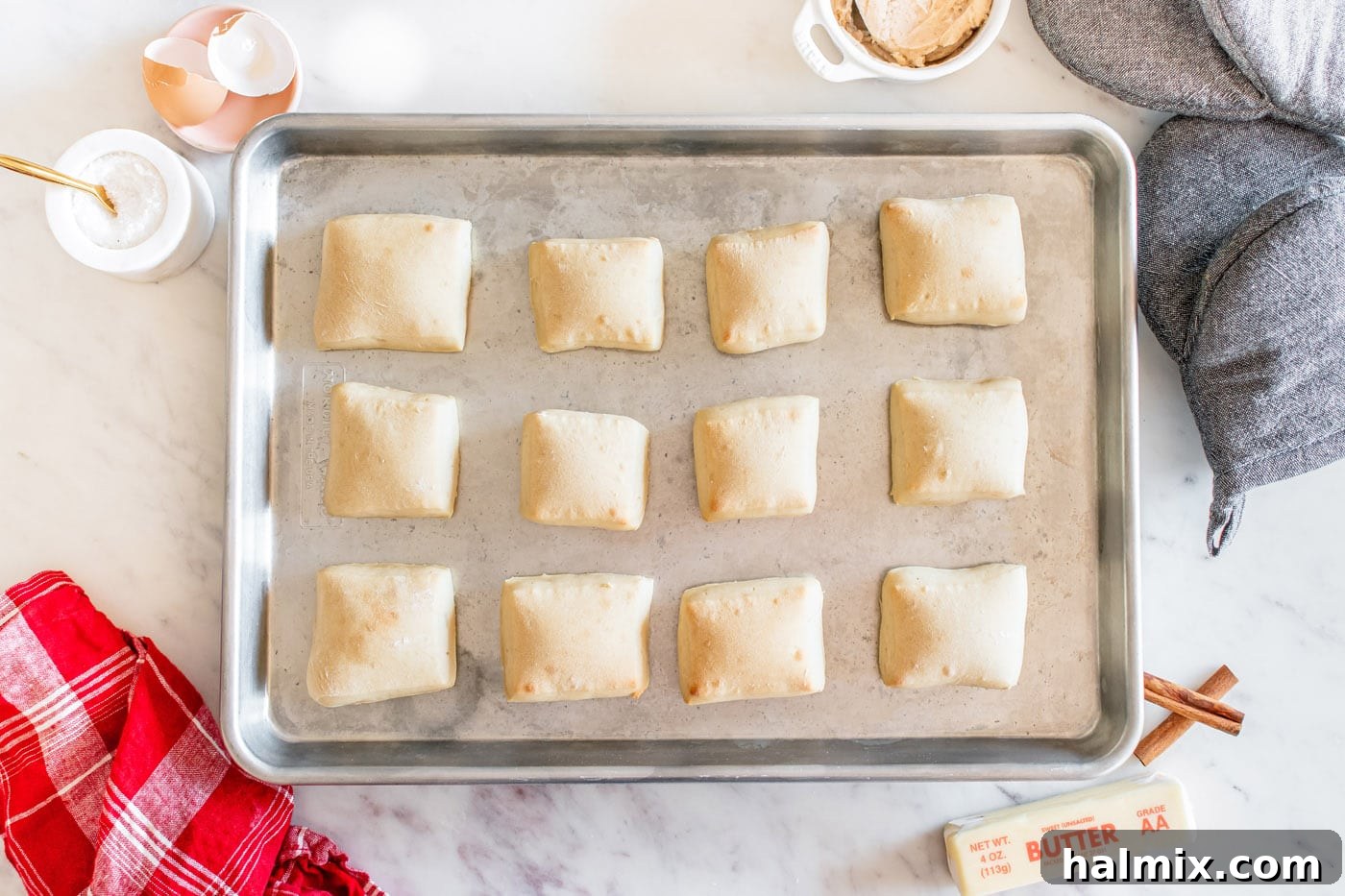 Baked square-shaped dinner rolls on a baking sheet, with a perfect golden-brown crust.