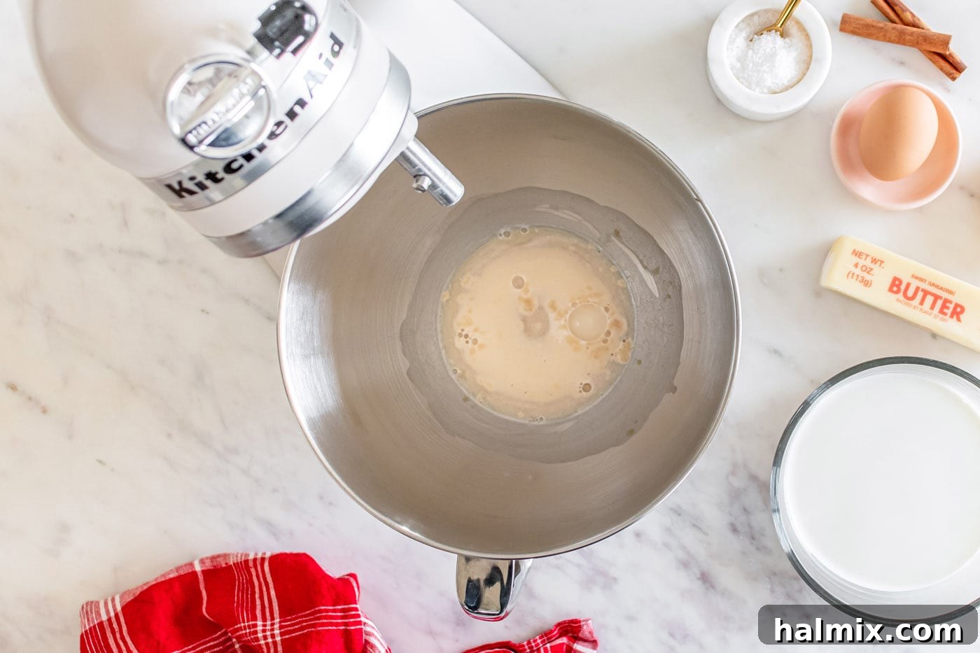 The foamy, doubled yeast mixture in a stand mixer bowl, indicating successful activation.