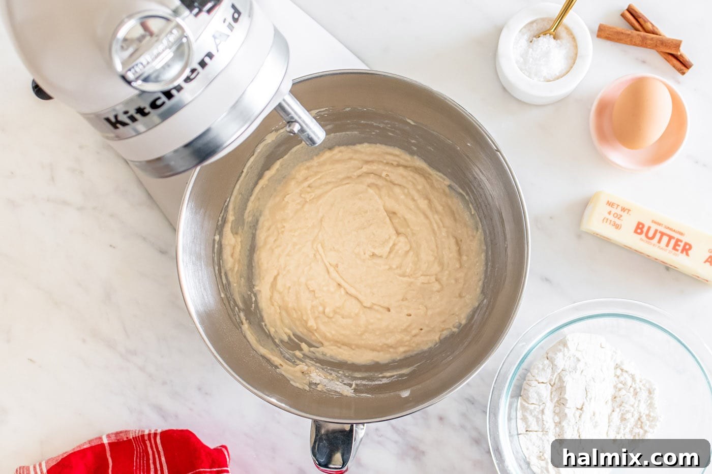 Well-kneaded, smooth dinner roll dough in a stand mixer bowl, ready for rising.