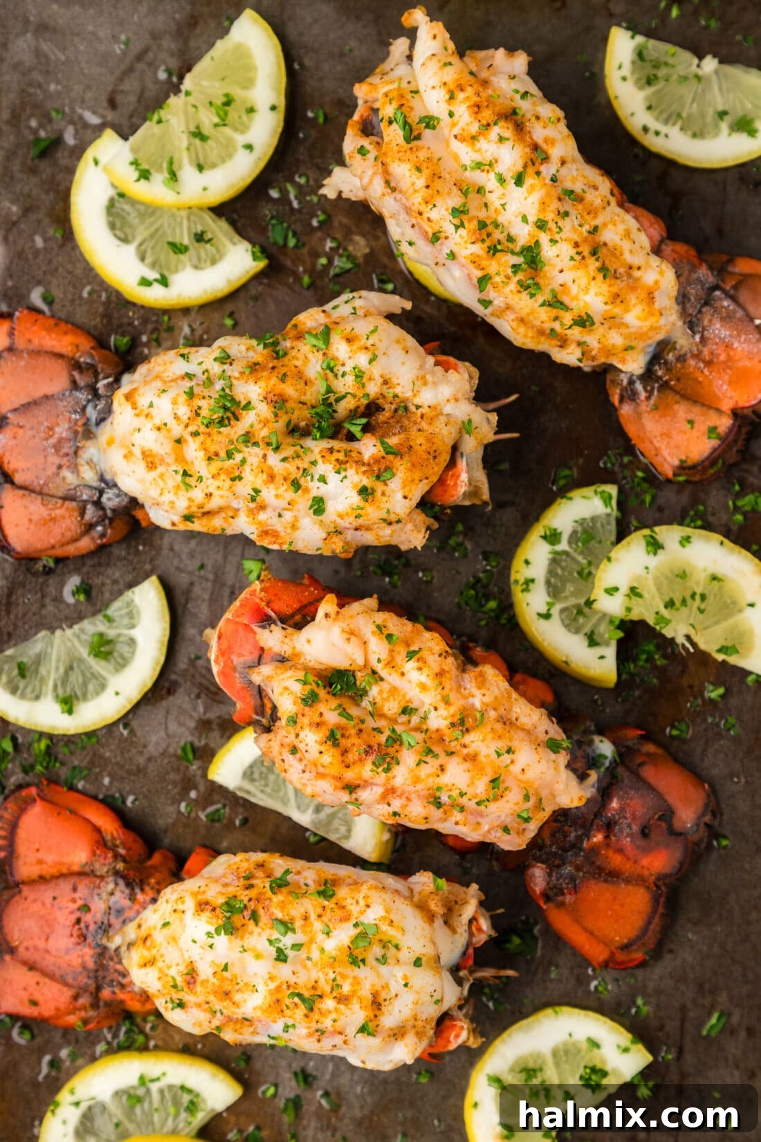 Baked Lobster Tails on a baking sheet with lemons