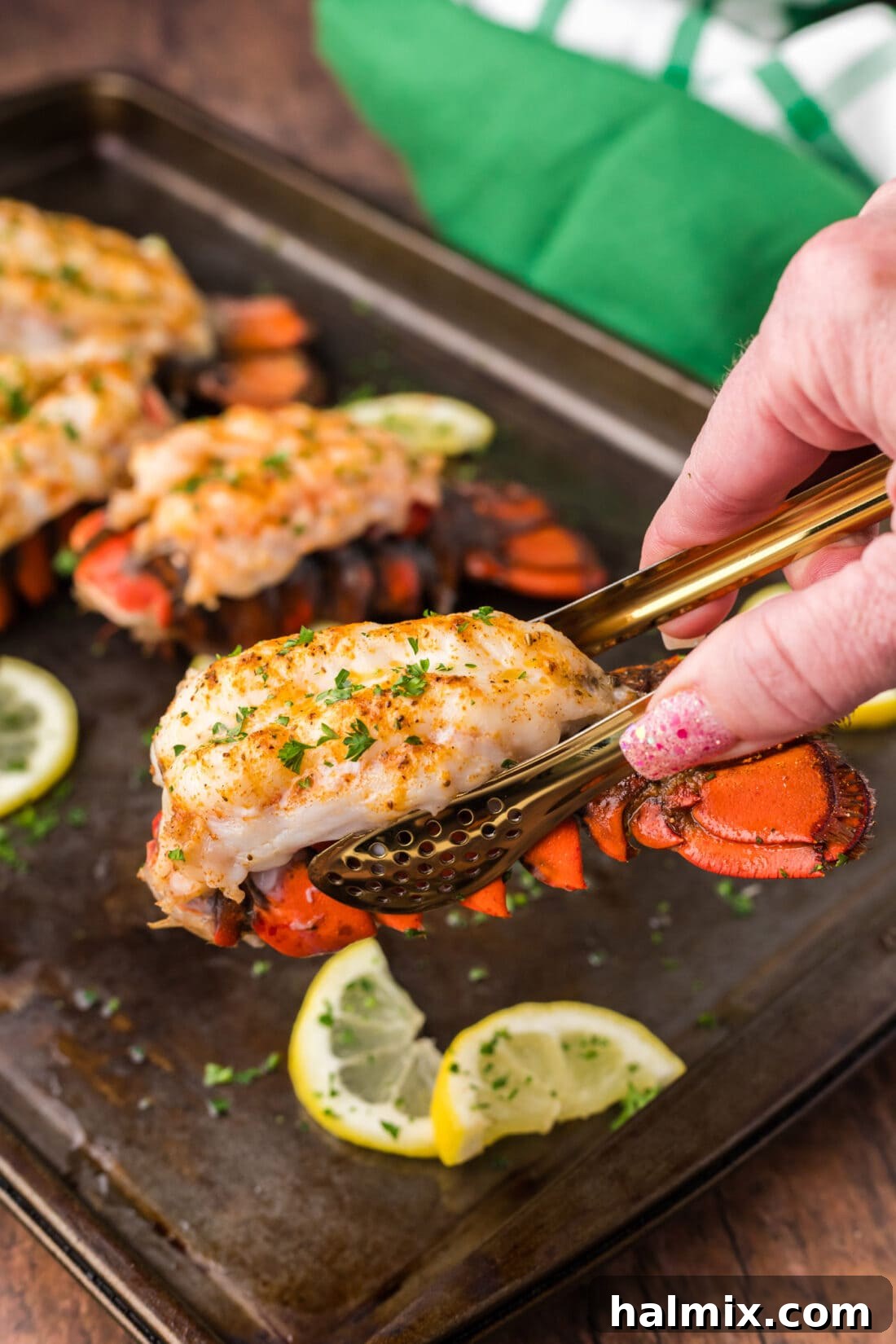 Tongs lifting up a Baked Lobster Tail
