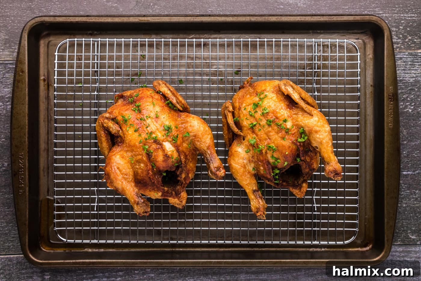 golden skinned deep fried cornish hens on a wire cooling rack