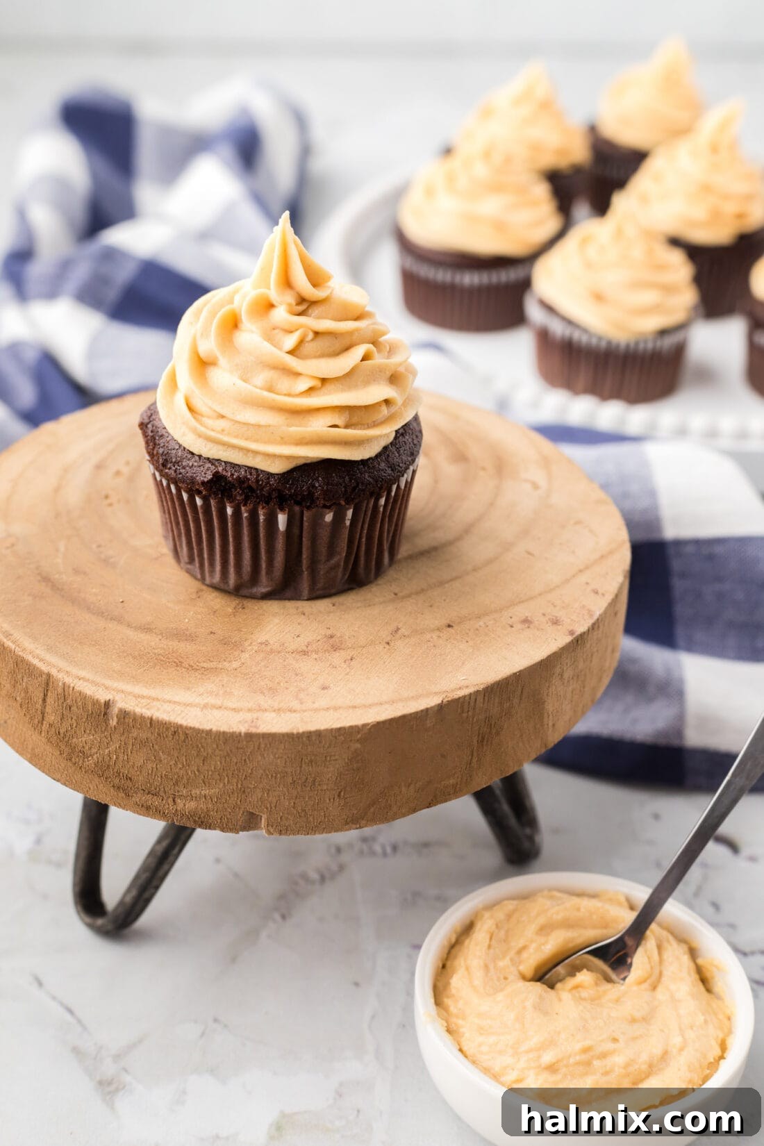 Cupcakes topped with creamy Peanut Butter Frosting and a bowl of frosting on the side