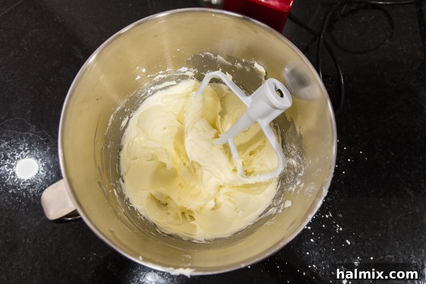 The whipped mixture of sugar, cream cheese, and butter in a bowl, showcasing its fluffy consistency